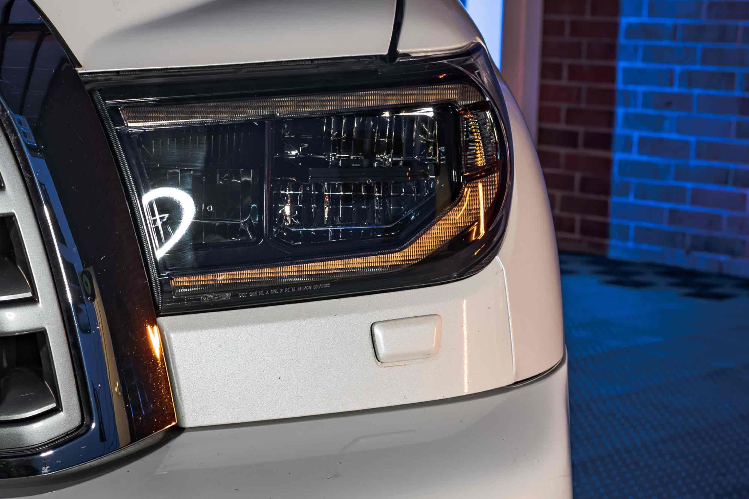 Close-up of Toyota Tundra LED headlight on white truck, modern auto lighting