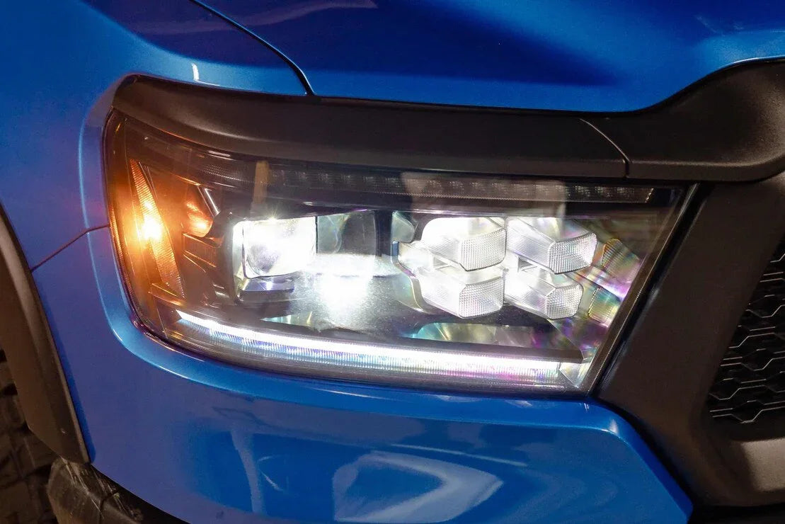 Close-up of LED headlight assembly on blue Ram 1500 truck