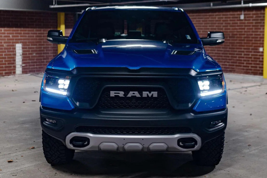 Blue Ram 1500 truck with LED headlights in a parking garage, front grille view