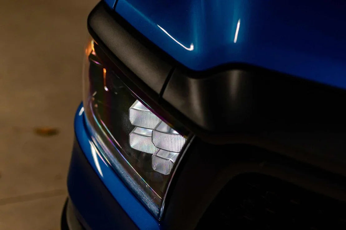 Close-up of LED headlight on a blue Ram 1500 truck, showcasing modern automotive lighting.