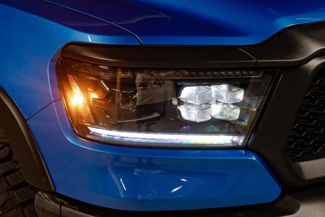 Close-up of blue Ram 1500 with upgraded XB LED headlights and amber turn signal on