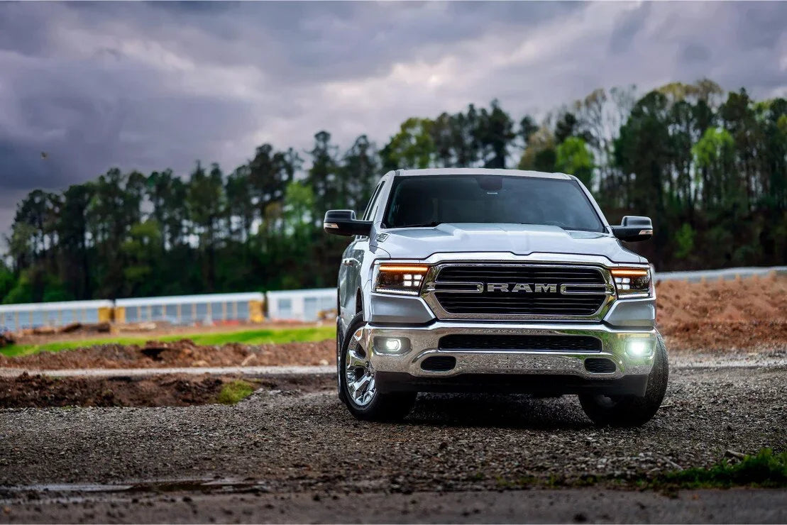 Front view of a white Ram 1500 truck with LED headlights on a gravel outdoor trail