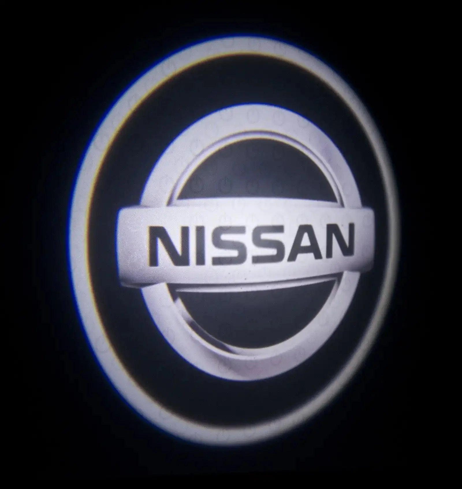 Nissan emblem illuminated in dark, circular car logo projection light