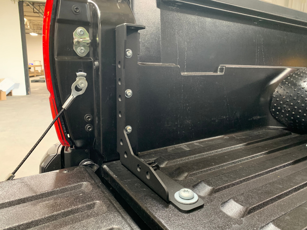 Truck bed accessory mounting bracket installed near tailgate, overland gear upgrade