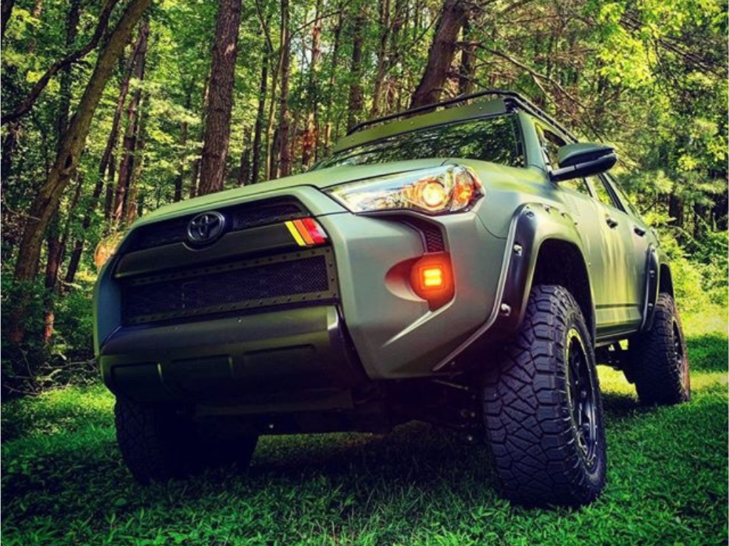Lifted Toyota 4Runner overlanding SUV with off-road tires parked in a forest setting