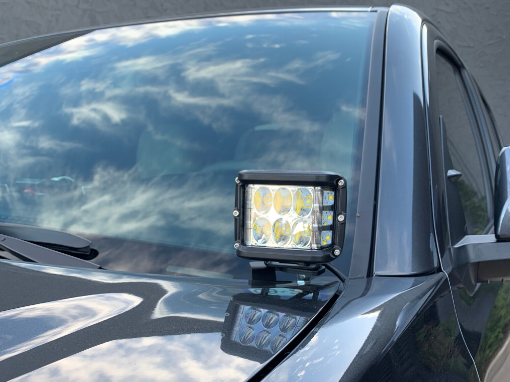 LED off-road light mounted on vehicle hood for overlanding and adventure camping