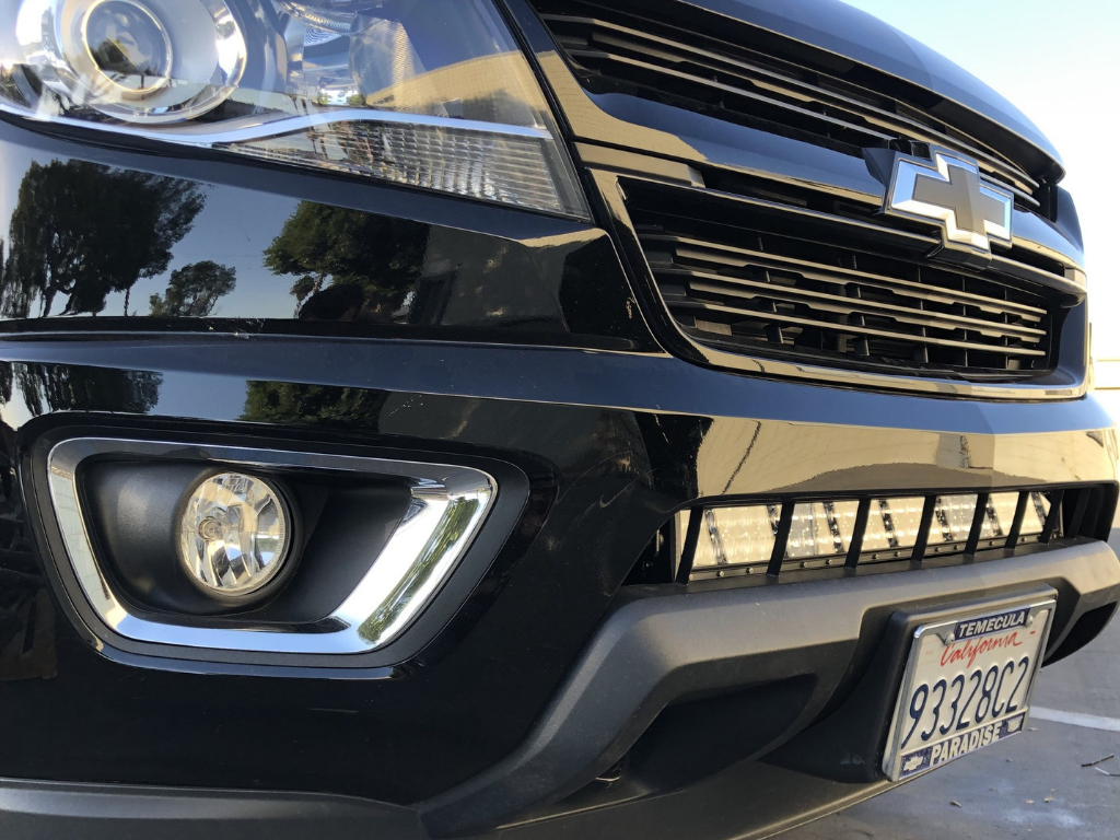 Close-up of Chevrolet front grille, fog light, and LED light bar upgrade on bumper