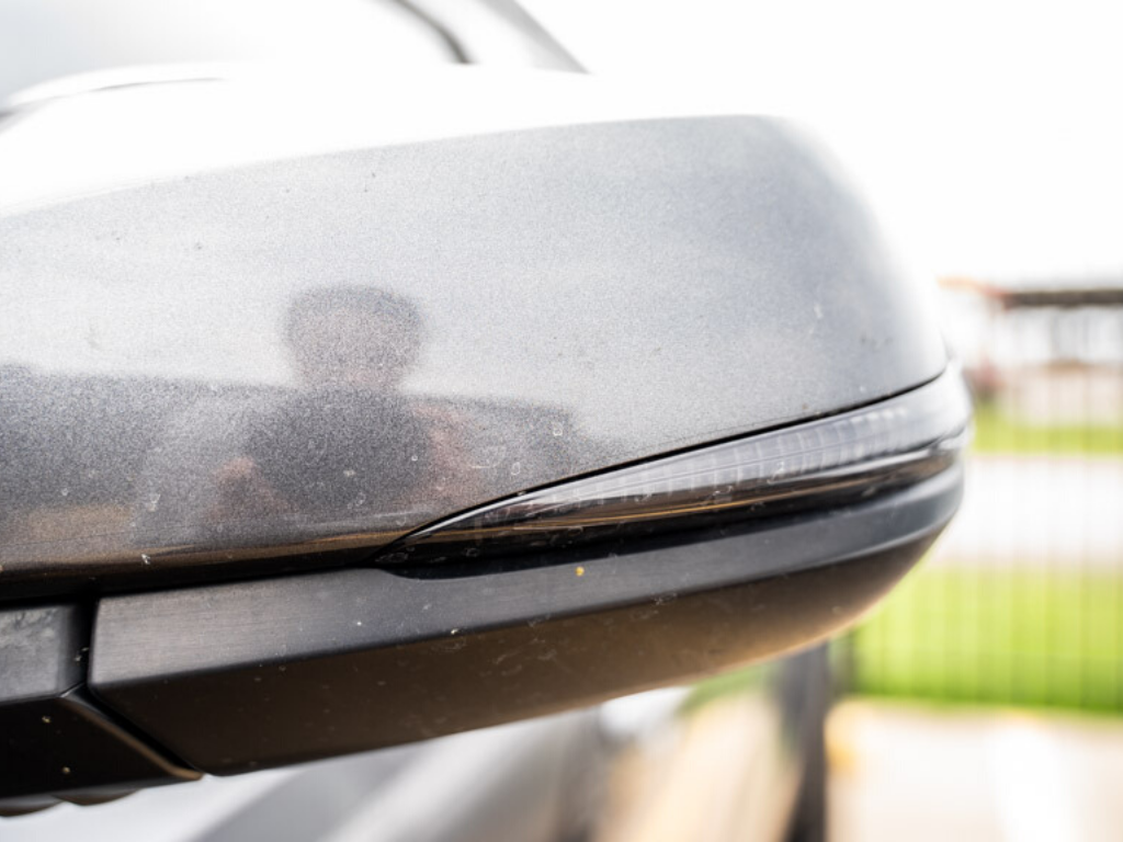 Close-up of a gray vehicle side mirror with integrated turn signal light