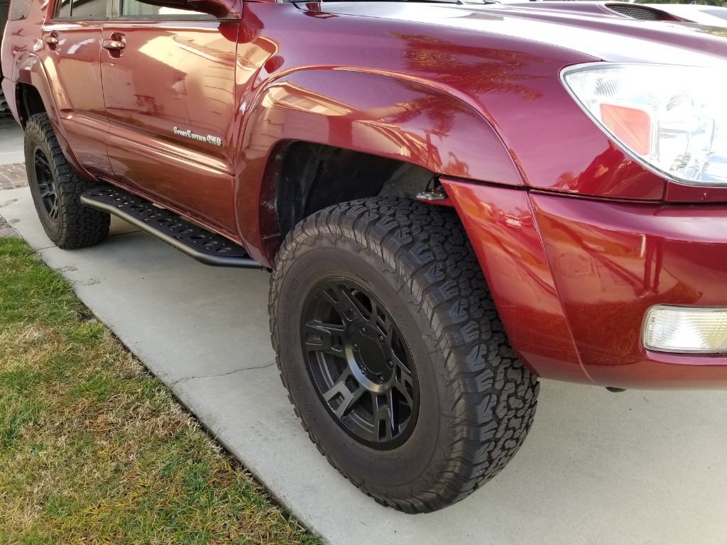 Toyota 4Runner with black off-road wheels and all-terrain tires on a driveway