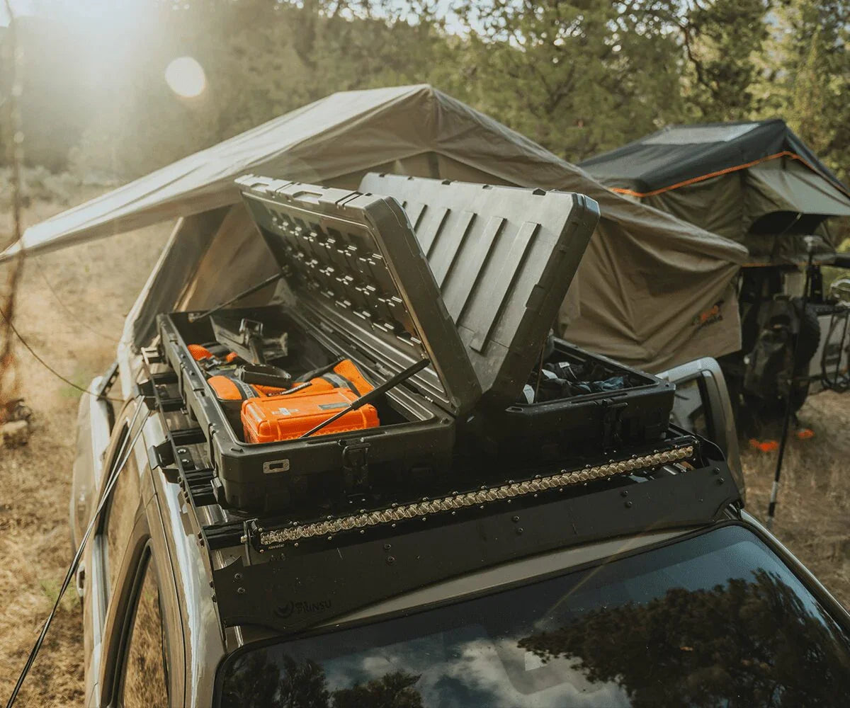 Nissan Frontier Prinsu roof rack with storage box and camping gear in outdoor setting