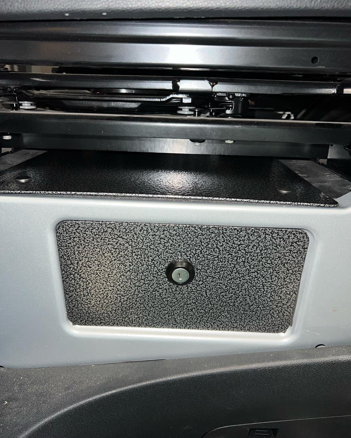 Diabolical Inc underseat lock box panel in a van passenger seat base