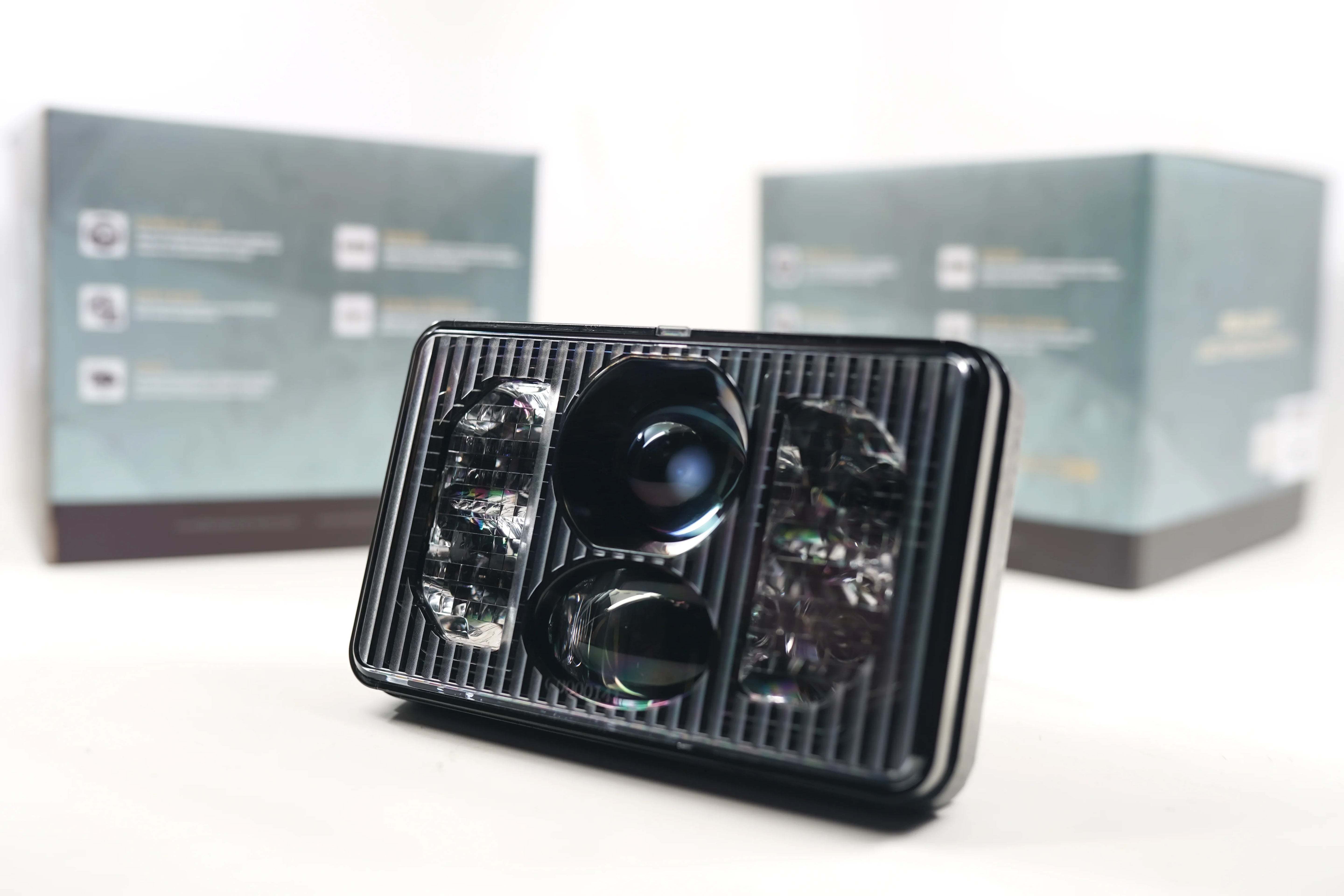 Rectangular bi-LED 4x6 headlight for off-road vehicles, shown with packaging boxes.