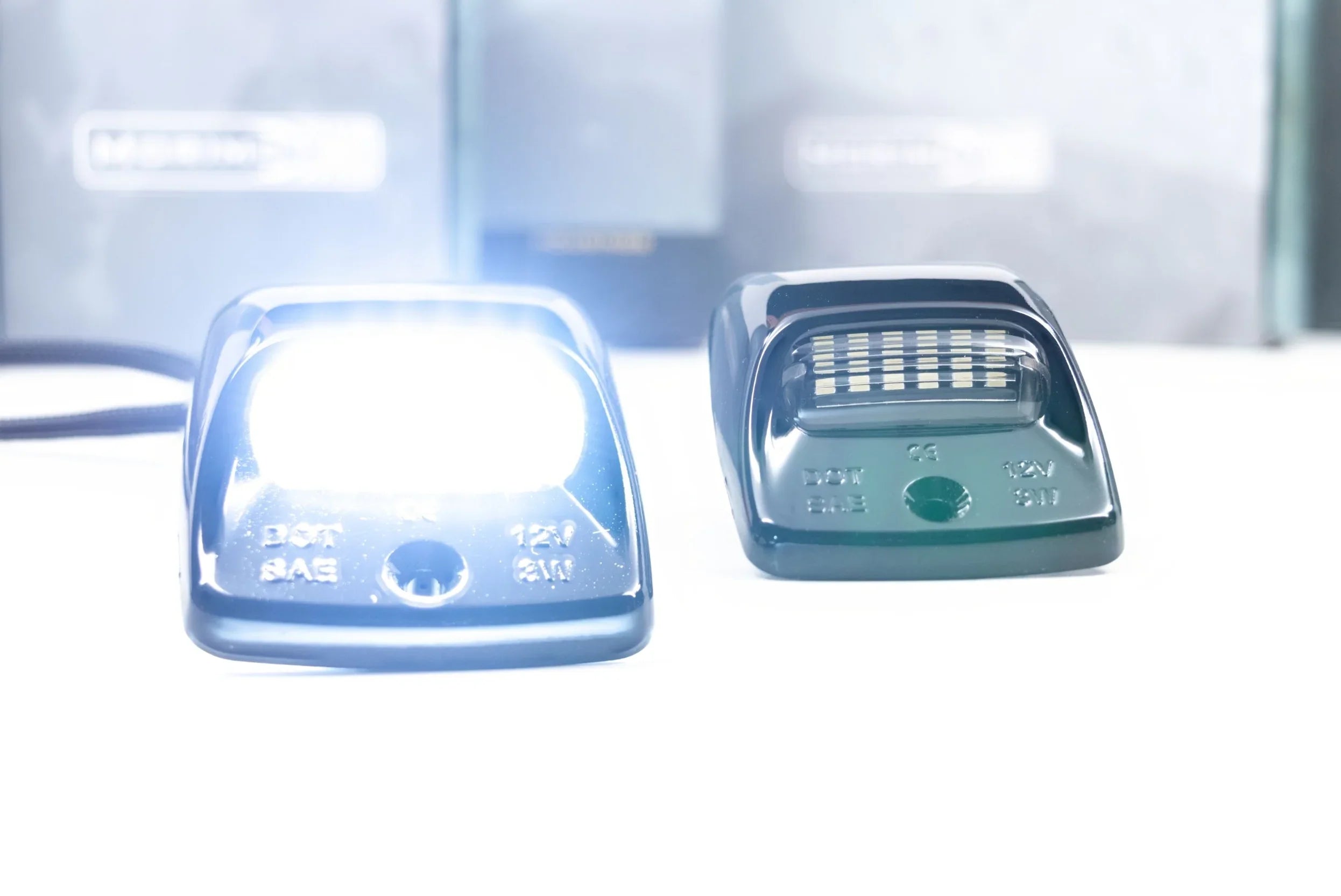Toyota Tacoma license plate LED lights, one illuminated, on a white surface