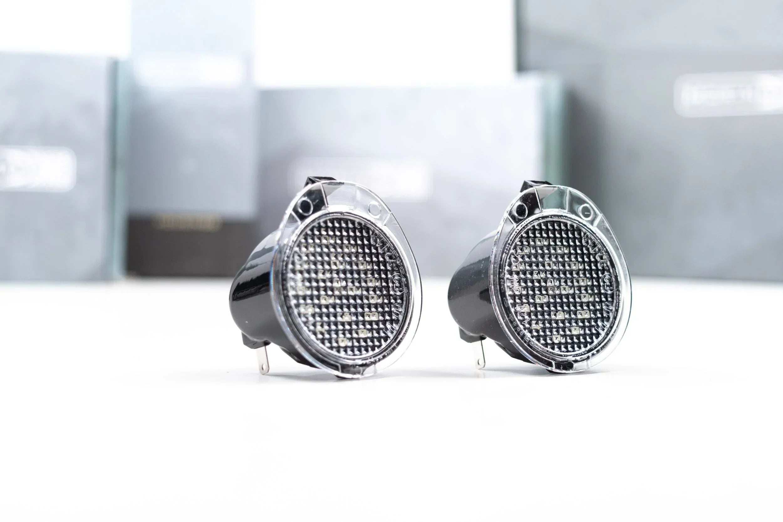 Pair of clear lens mirror lights for Toyota Tundra, black housing, on white background