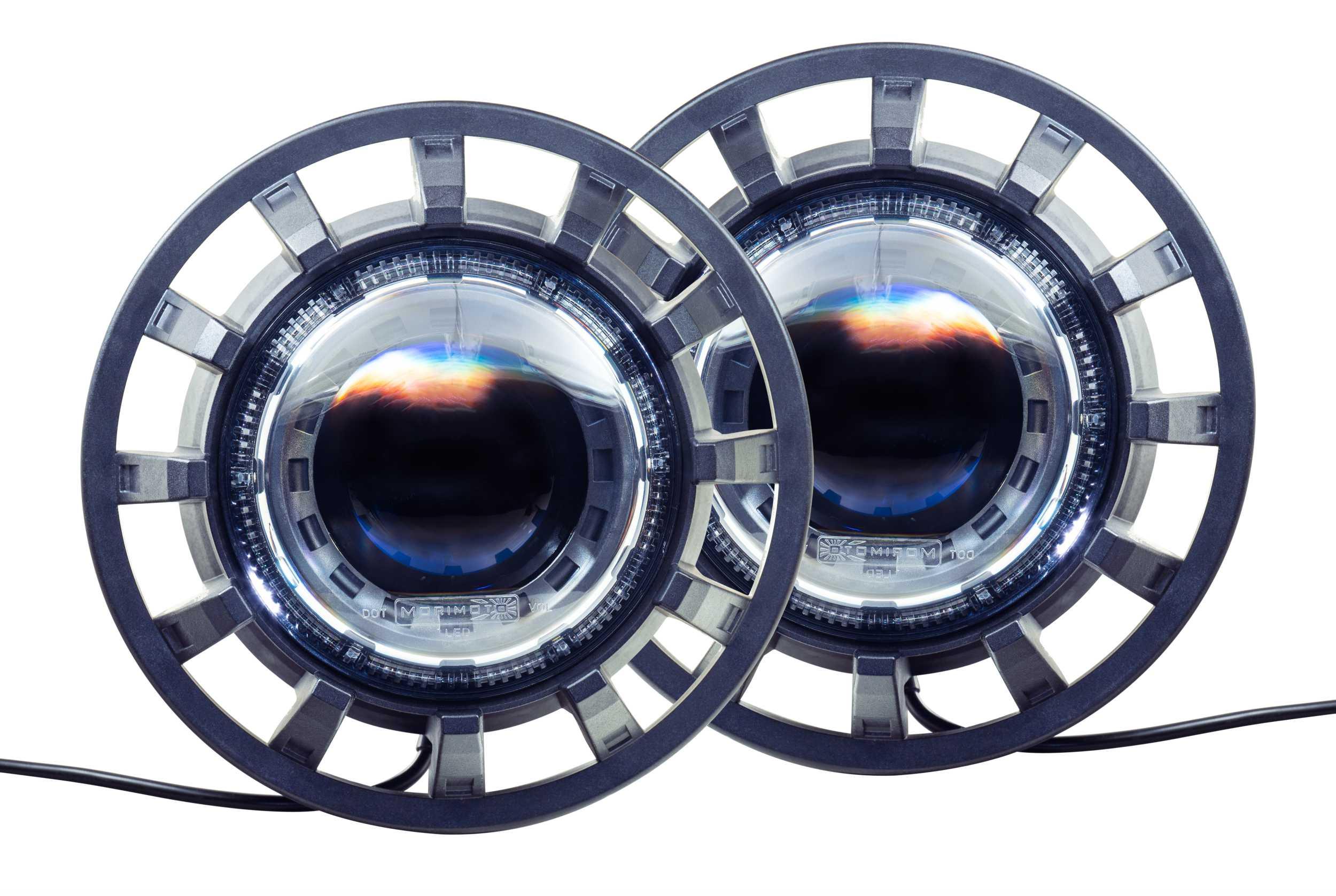 Pair of round automotive LED projector headlights with black housing, close up