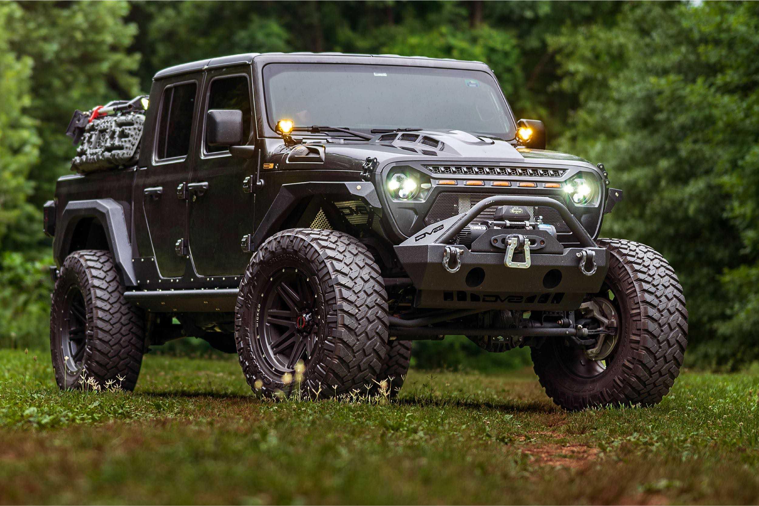 Lifted Jeep Gladiator with off-road tires, aftermarket bumper, and overlanding gear parked outdoors