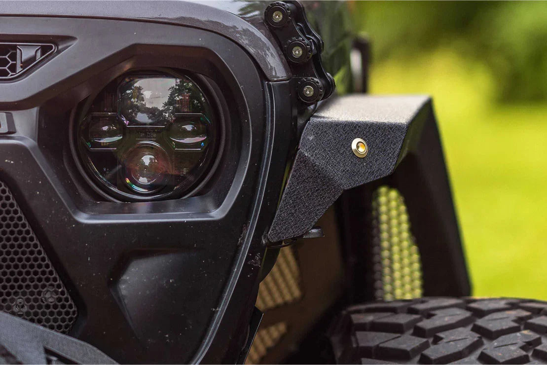 Close-up of rugged off-road vehicle headlight, textured fender, and all-terrain tire