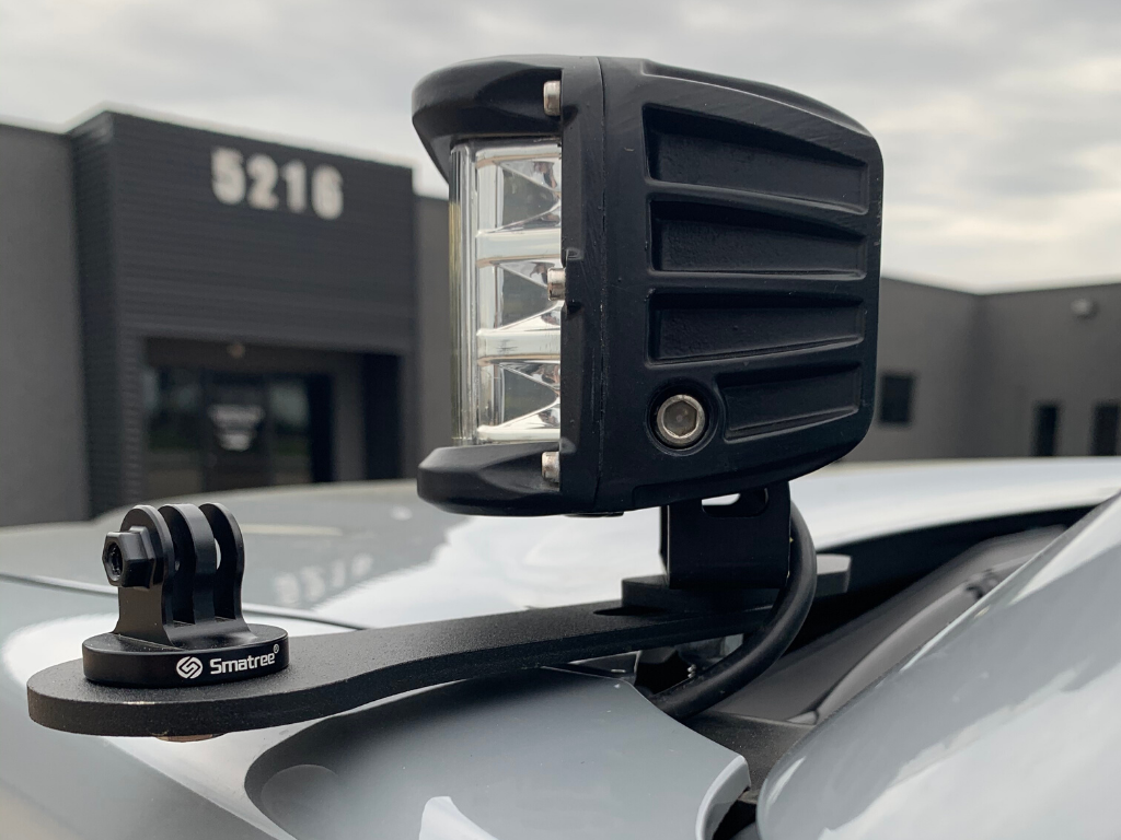 LED off-road light and camera mount on vehicle roof rack, outdoor setting