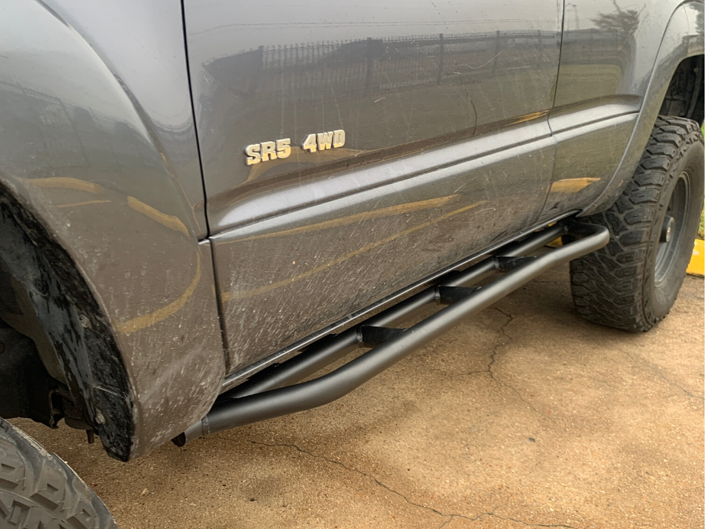 Black rock sliders installed on Toyota SR5 4WD, off-road vehicle protection accessory