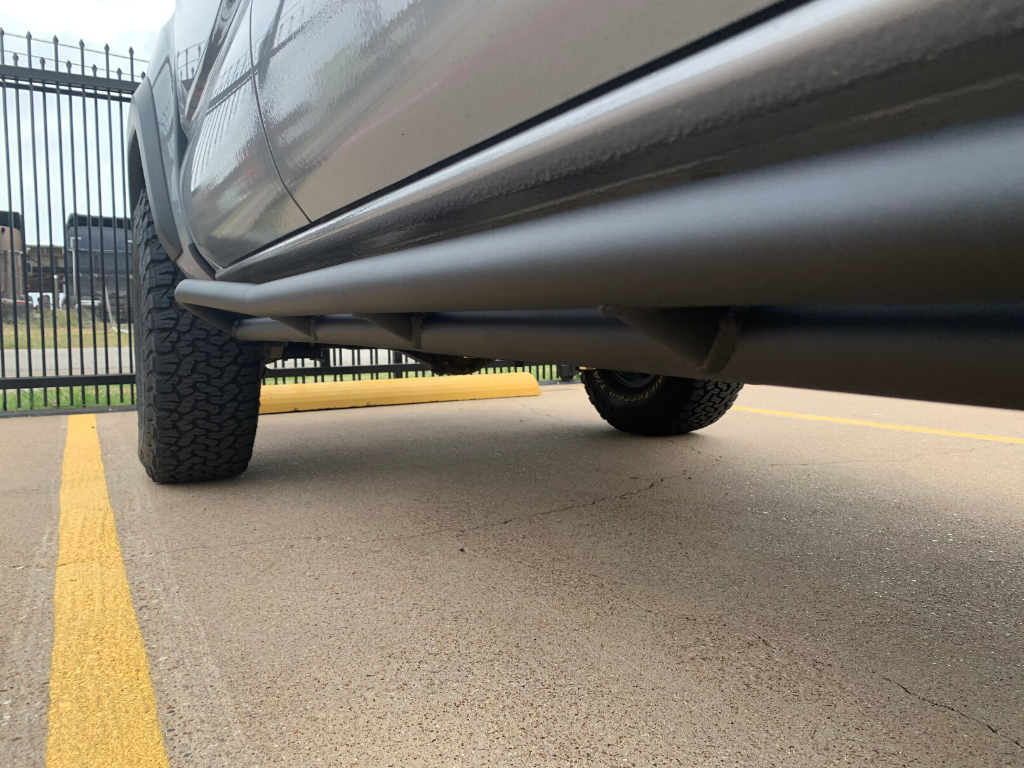 Off-road truck with heavy-duty rock sliders and all-terrain tires in parking lot