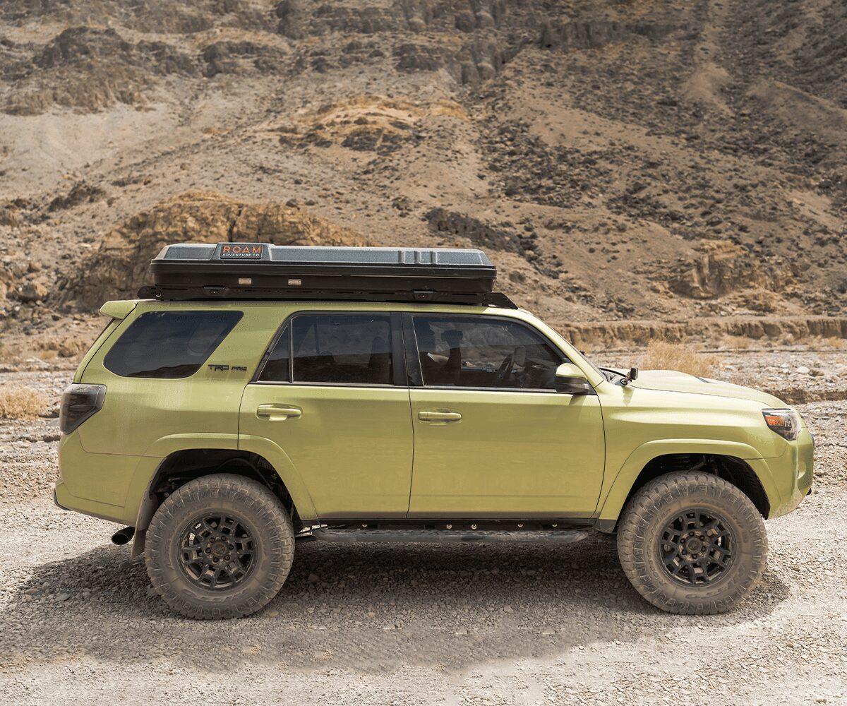 Toyota 4Runner with Prinsu roof rack and rooftop tent in a rugged desert landscape
