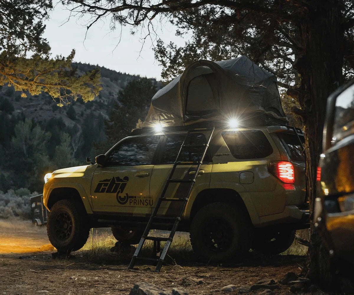 Toyota 4Runner with Prinsu roof rack, camp lights, rooftop tent, and ladder in outdoor setting