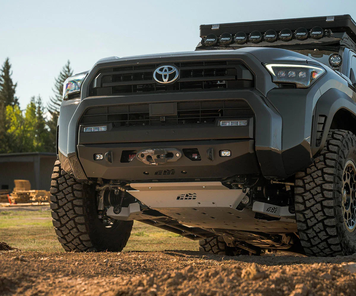 Toyota 4Runner with off-road tires, skid plate, and roof lights on rugged outdoor terrain