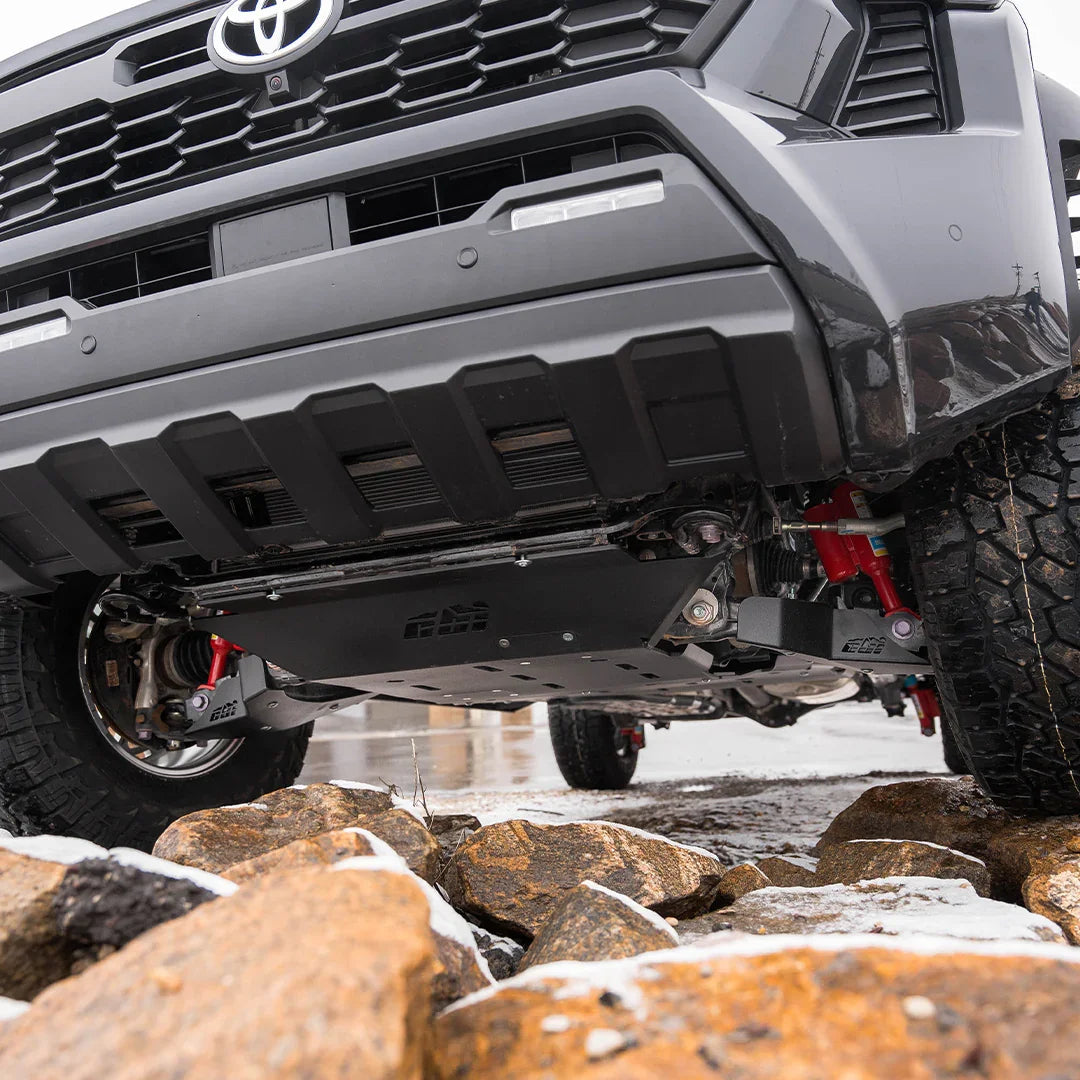 Toyota Tacoma with skid plates and off-road suspension over rocky terrain