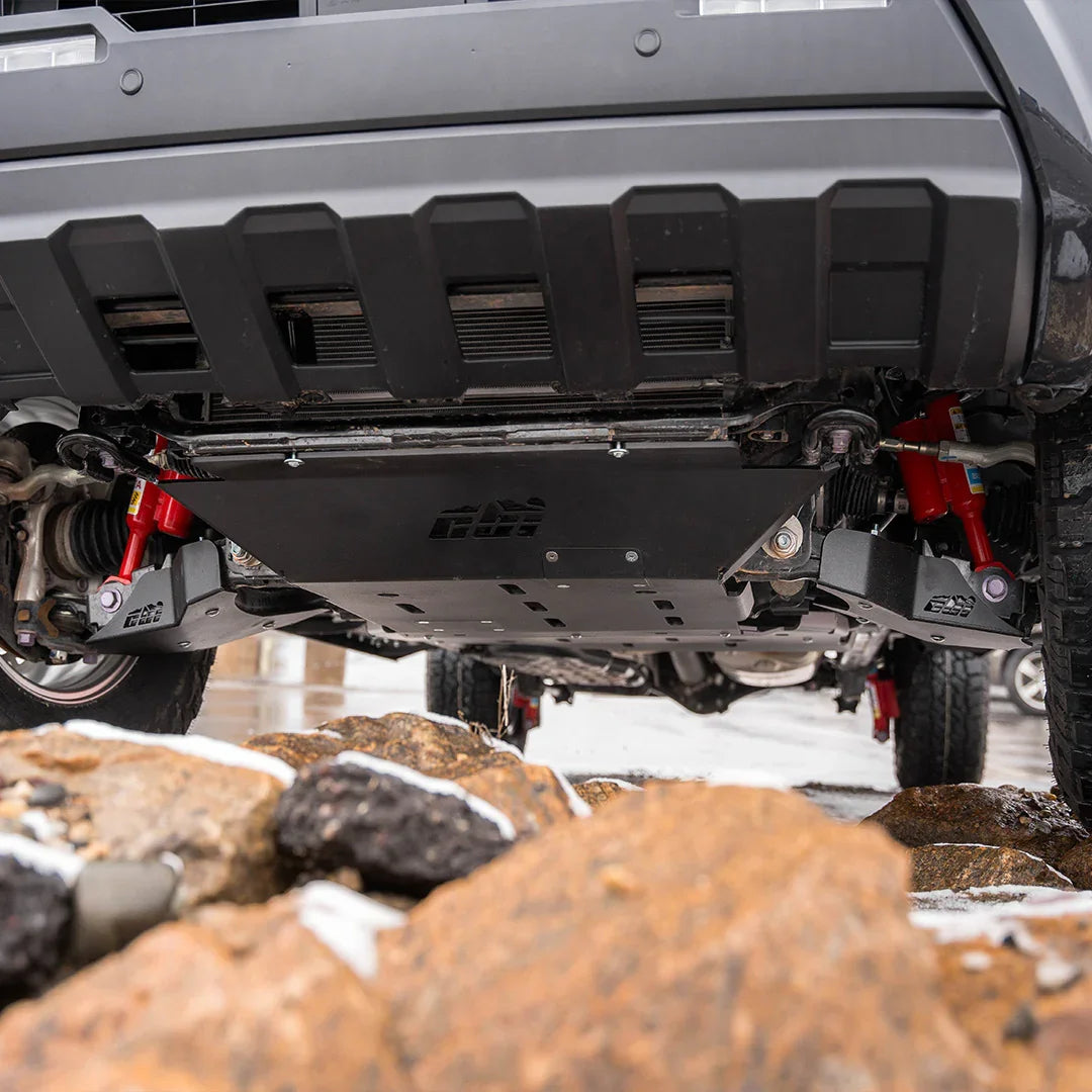 Toyota Tacoma skid plates installed, shown from below over rocky terrain.
