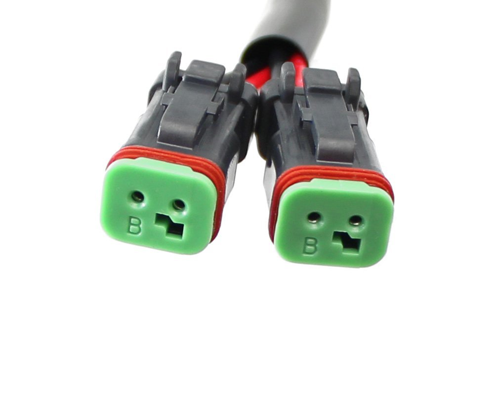 Close-up of dual green automotive waterproof electrical connectors for vehicle wiring harness
