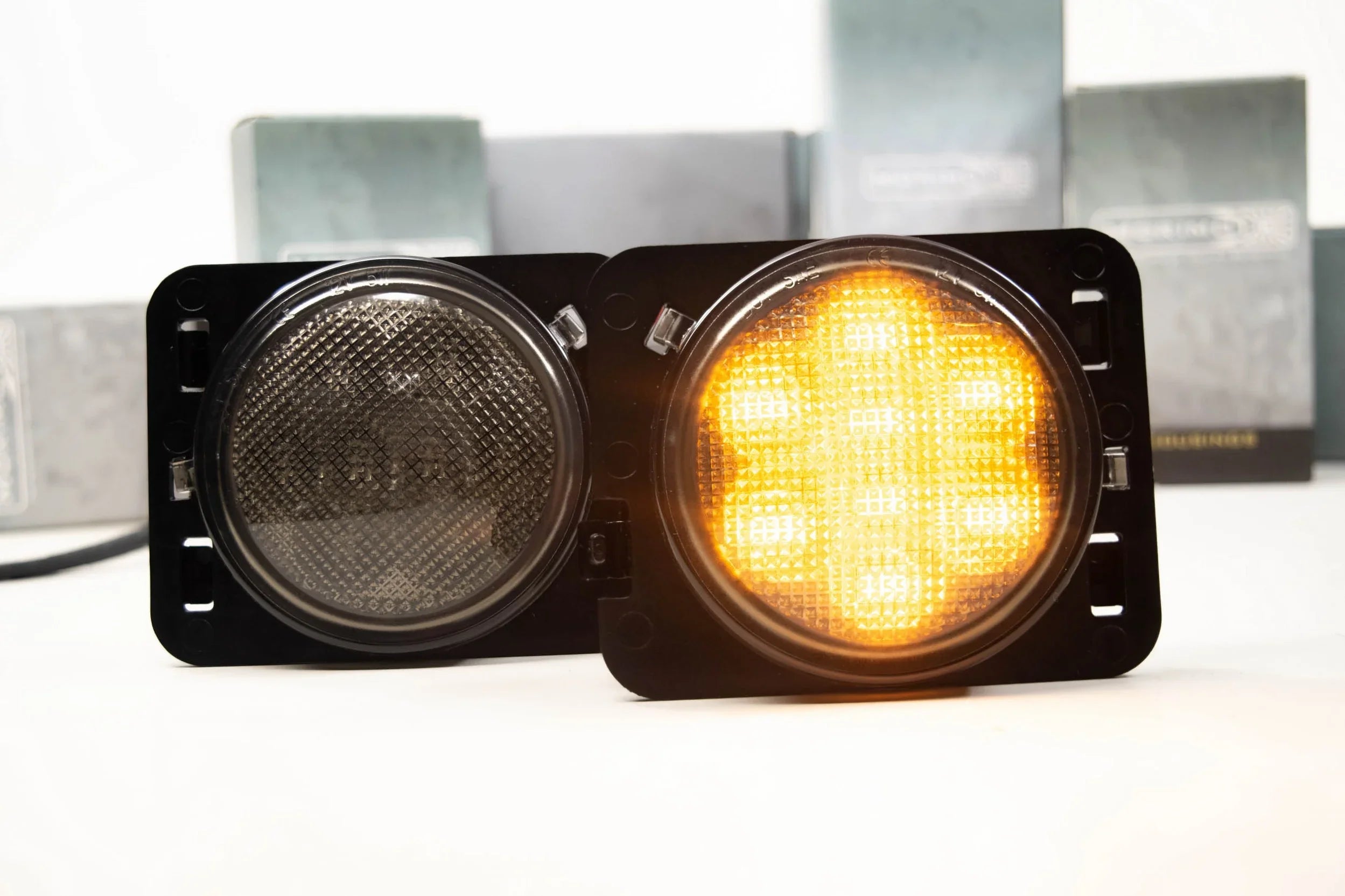 LED parking lights for Jeep Wrangler JK, one smoked and one illuminated amber, close-up view