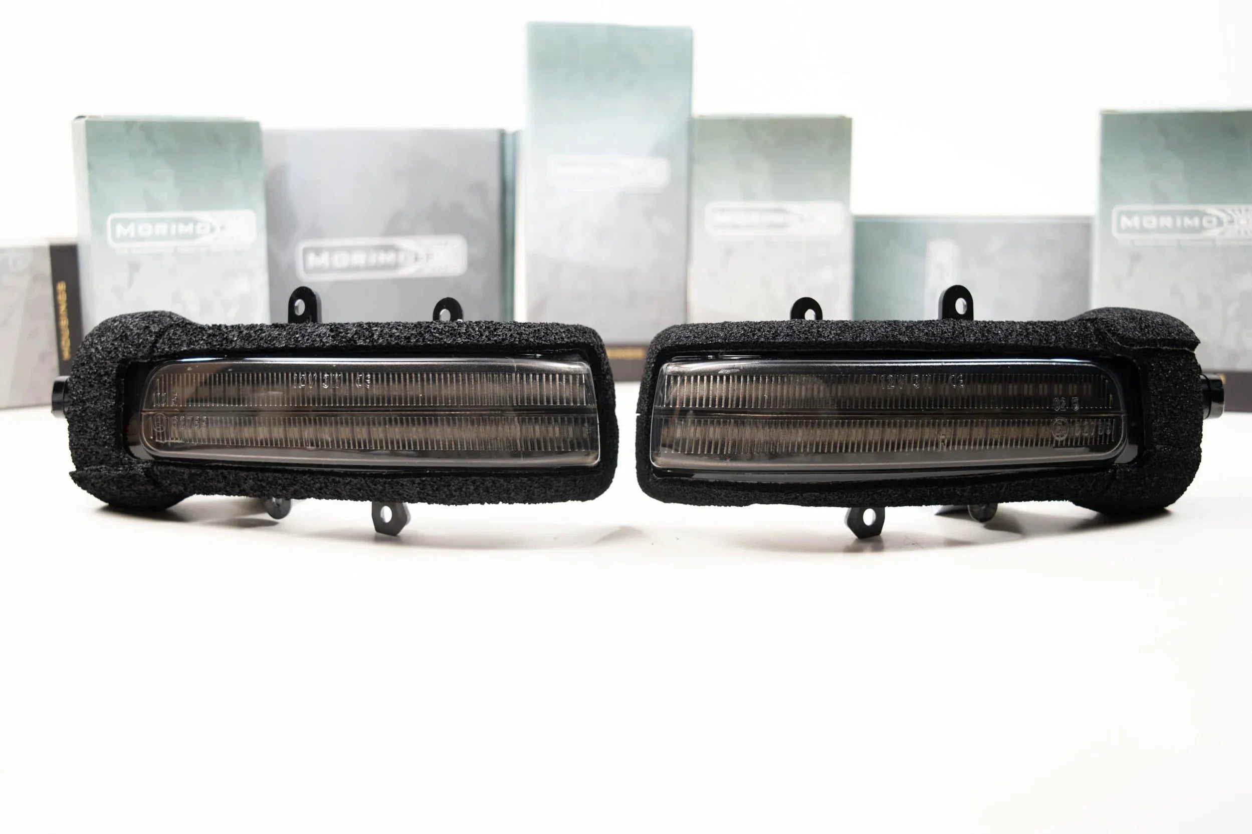 Pair of smoked lens LED mirror lights for Toyota Tacoma, displayed on a white background.