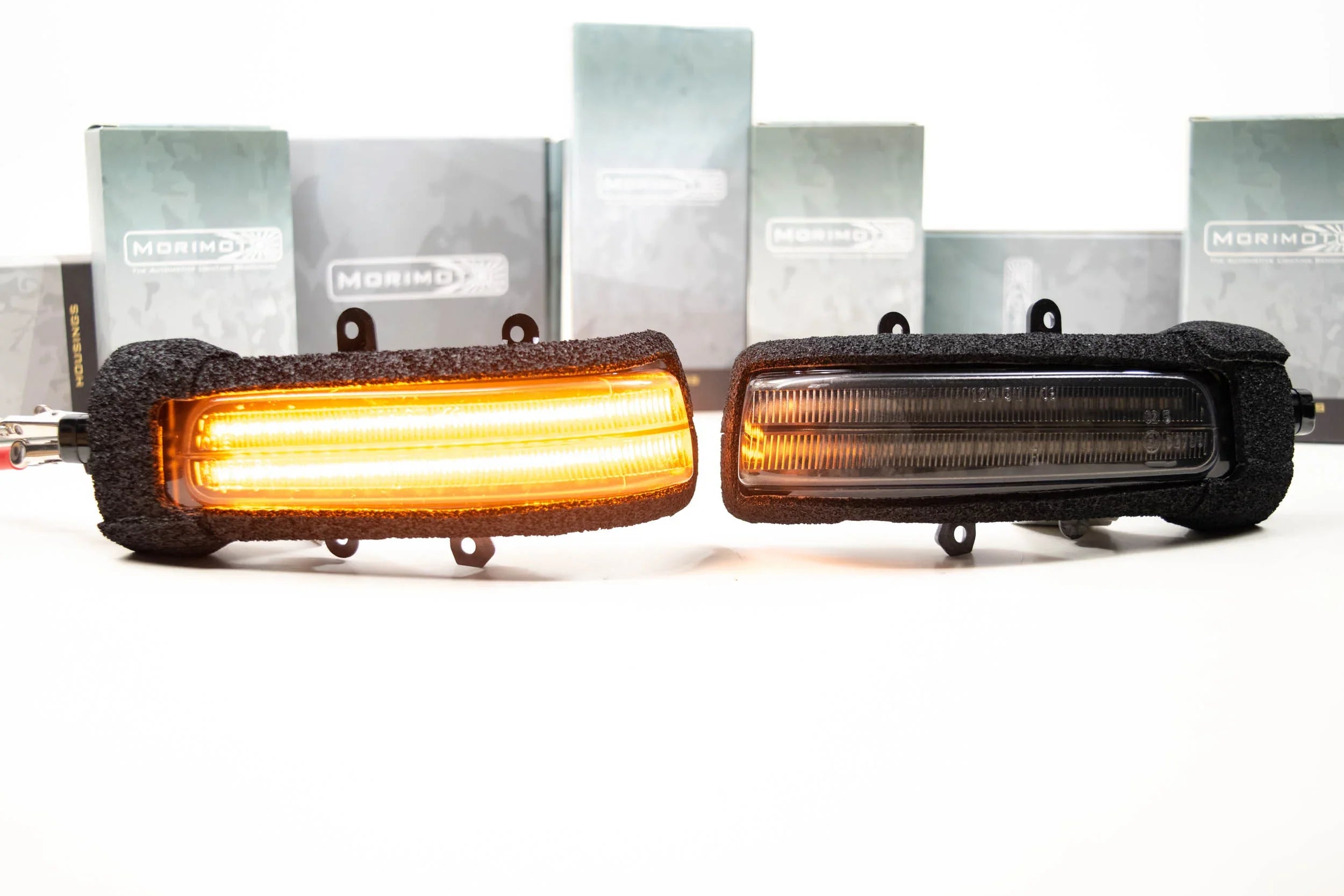 Toyota Tacoma aftermarket smoked mirror lights with amber LED, product comparison on white