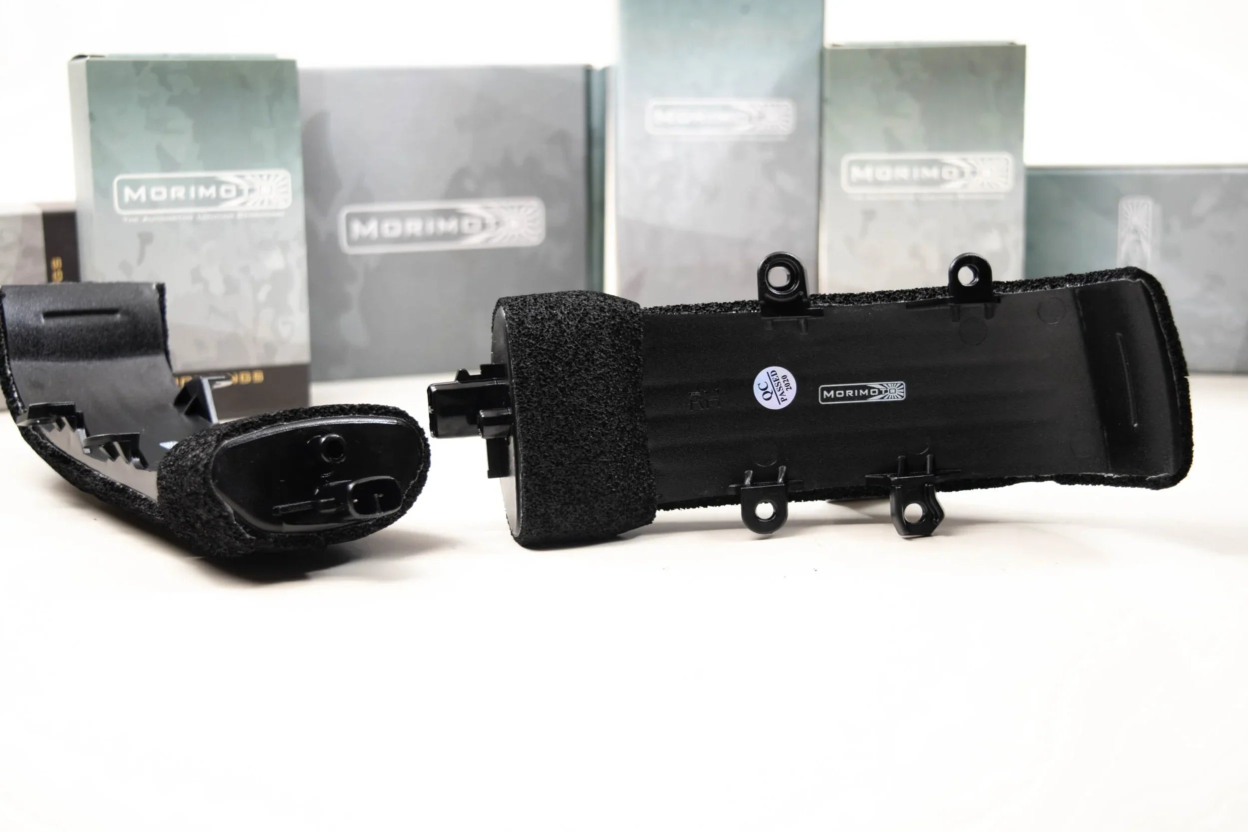 Close-up of Morimoto mirror turn signal lights for Toyota Tacoma, black housing, on table.
