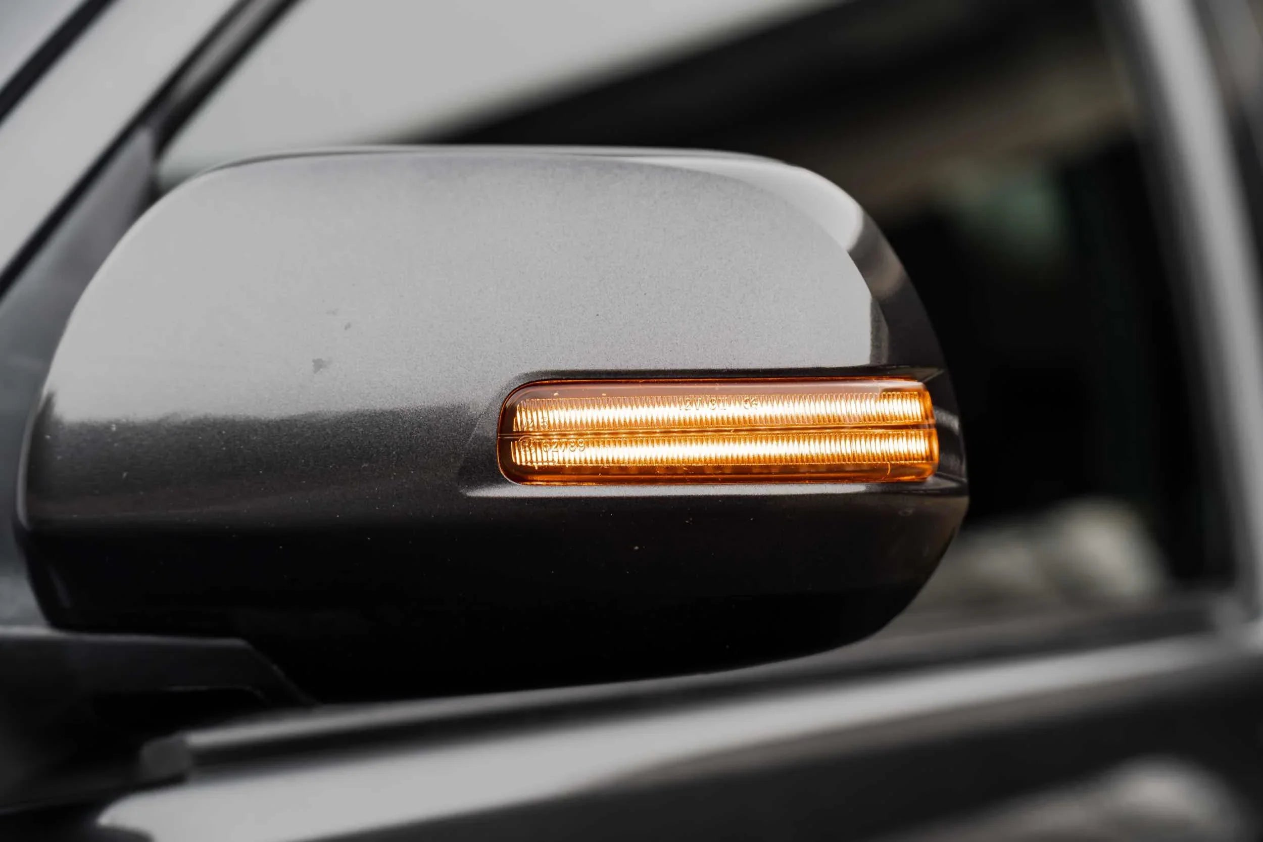 Close-up of Toyota Tacoma side mirror with integrated amber LED turn signal light
