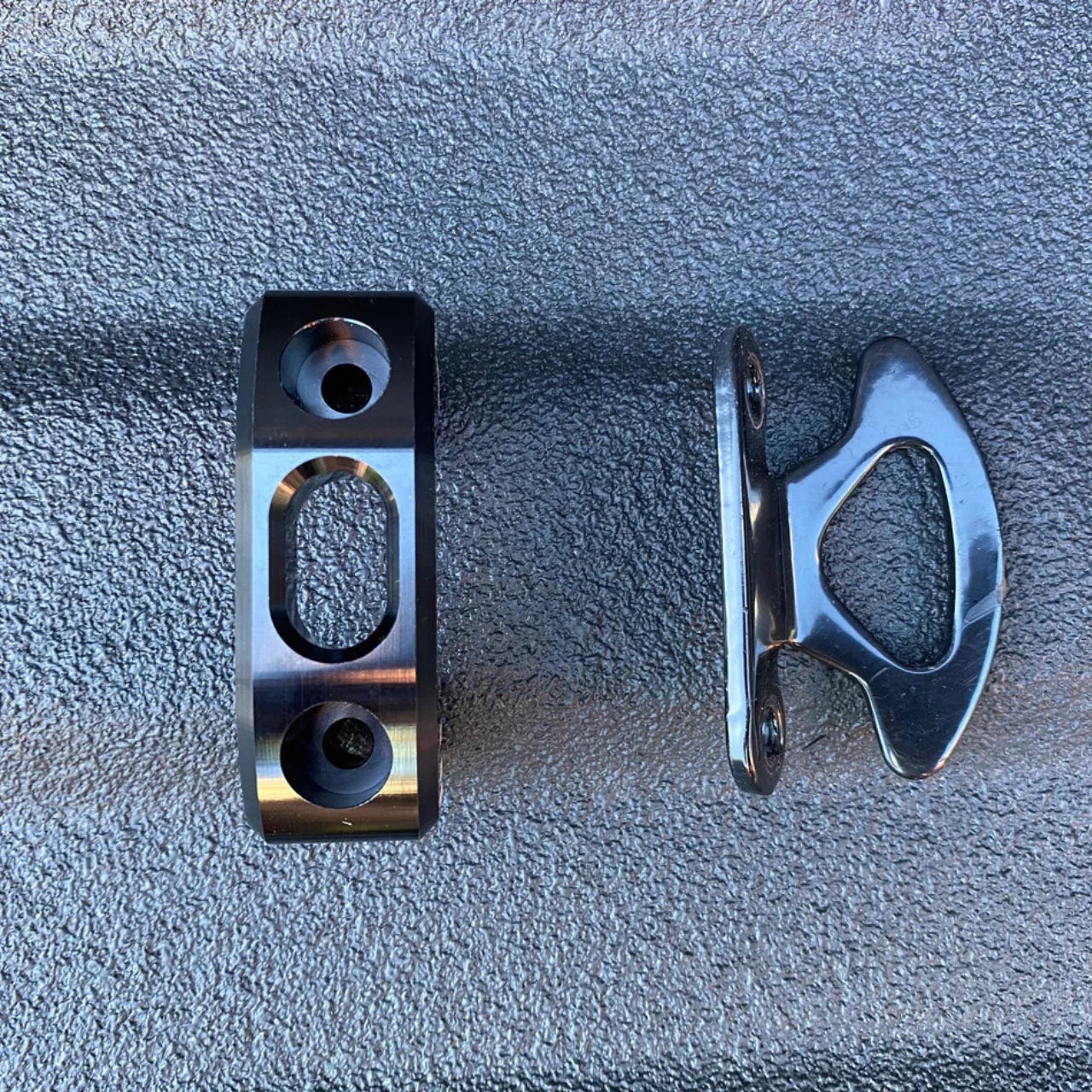 Metal mounting brackets for off-road vehicle gear on textured surface