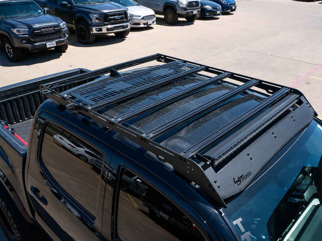 Overhead view of a pickup truck with a Prinsu roof rack, parked among other vehicles.
