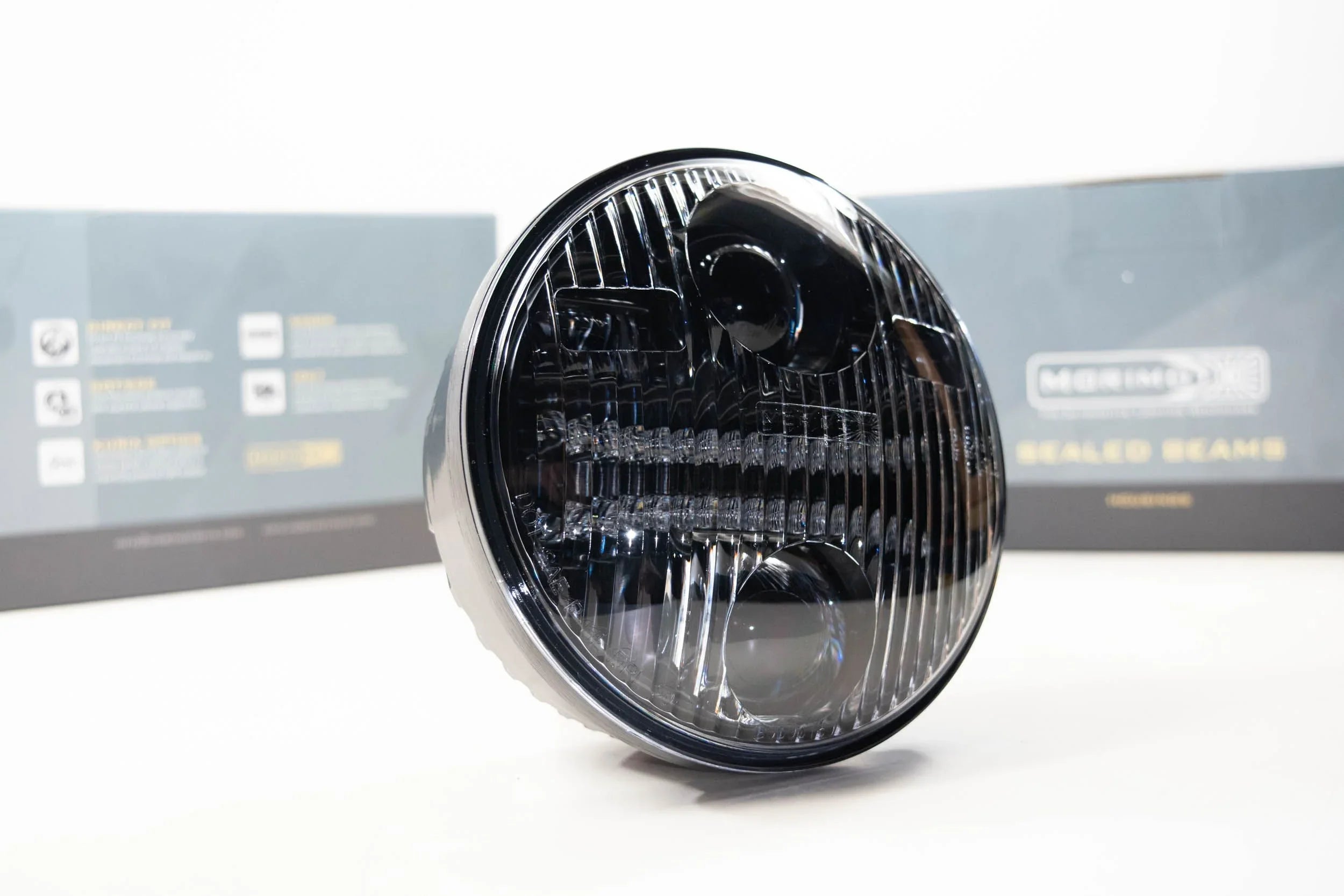 Round black sealed beam LED headlight for off-road vehicles, shown on white background