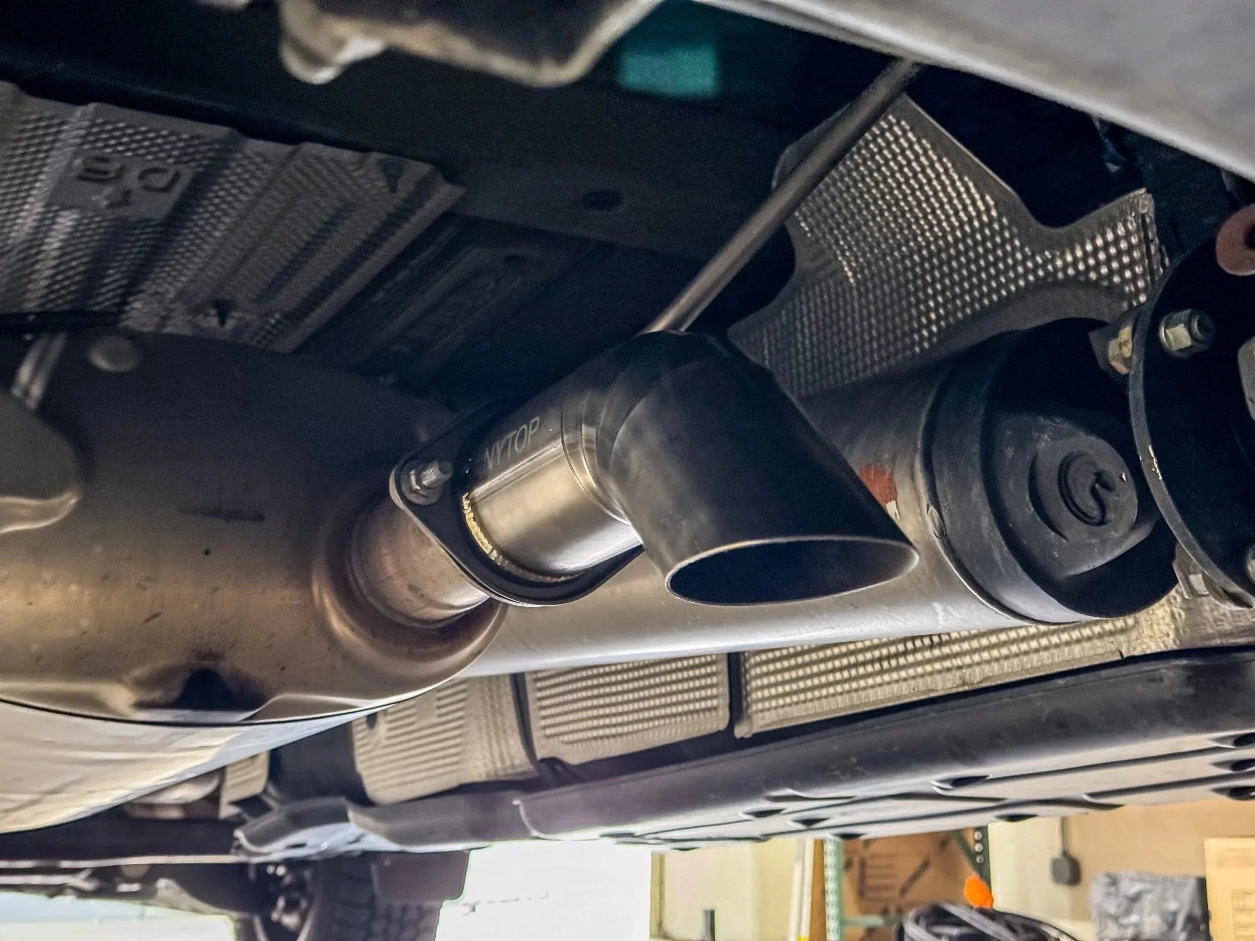 Close-up of a vehicle exhaust tip and catalytic converter under a truck, suitable for off-road vehicles.
