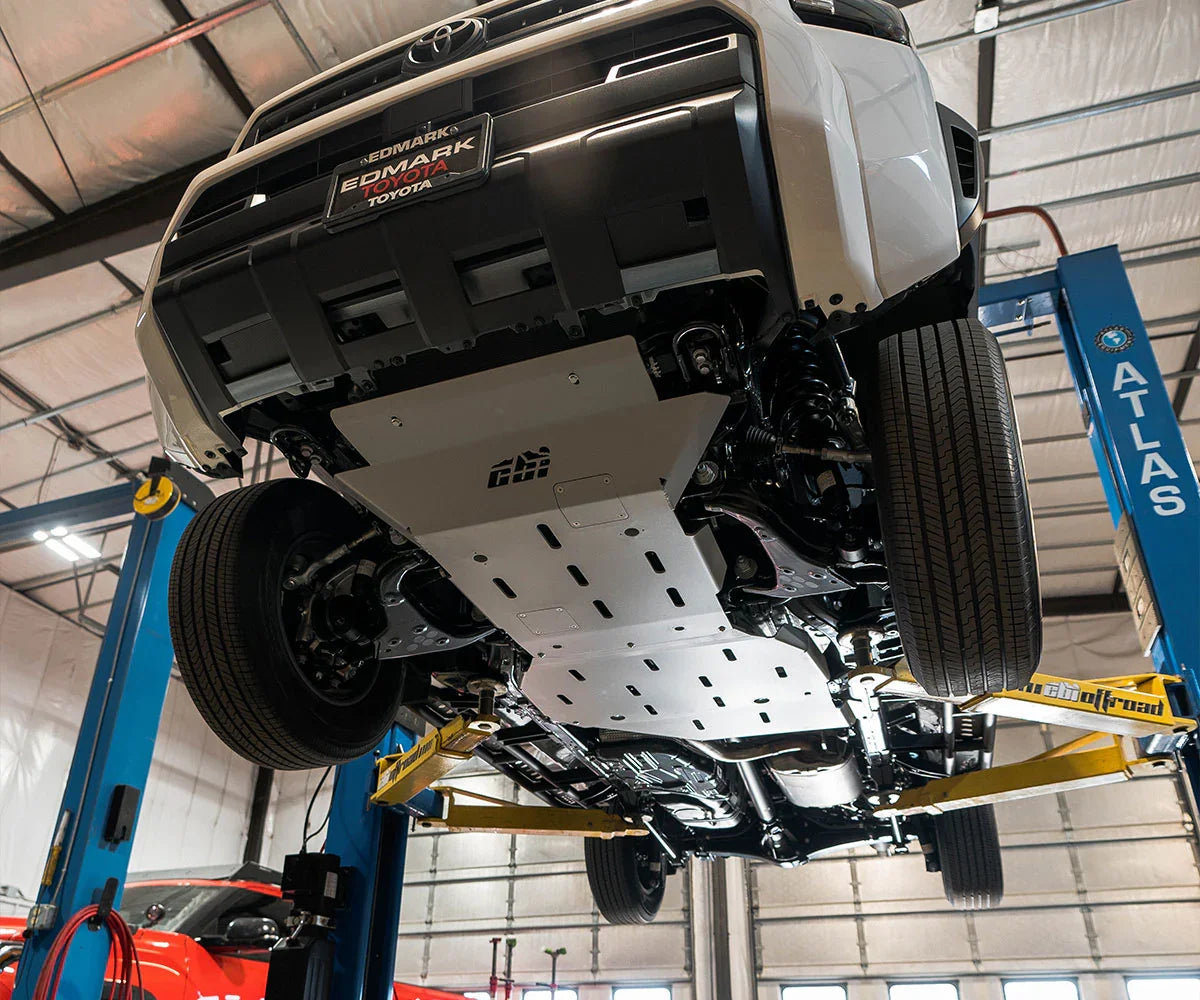 Toyota 4Runner on lift displaying installed skid plates for off-road protection.