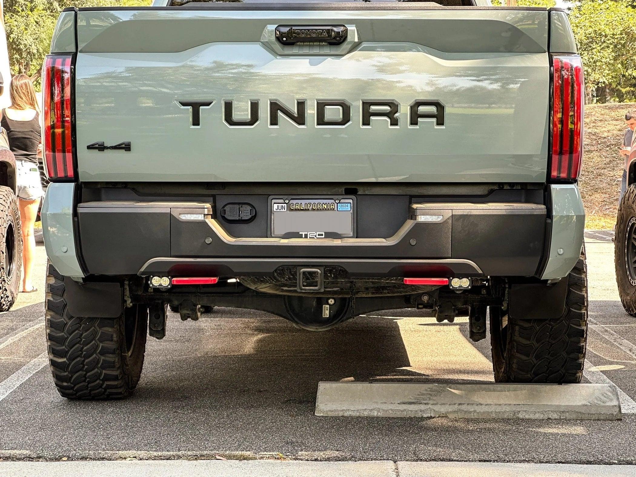 Lifted Toyota Tundra TRD 4x4 rear view showing off-road tires and tailgate in parking lot