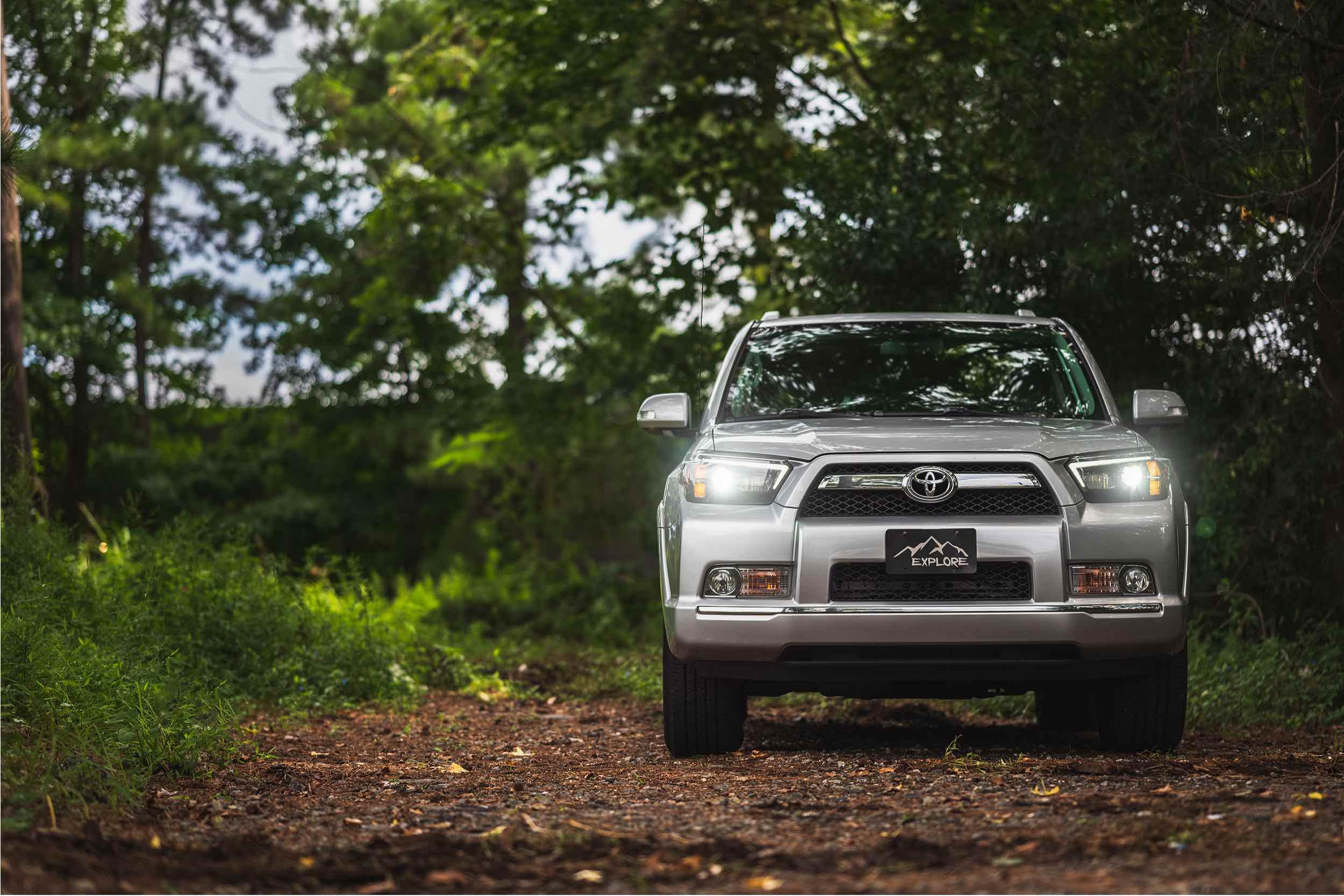 Toyota 4Runner parked on a dirt trail in a wooded outdoor setting