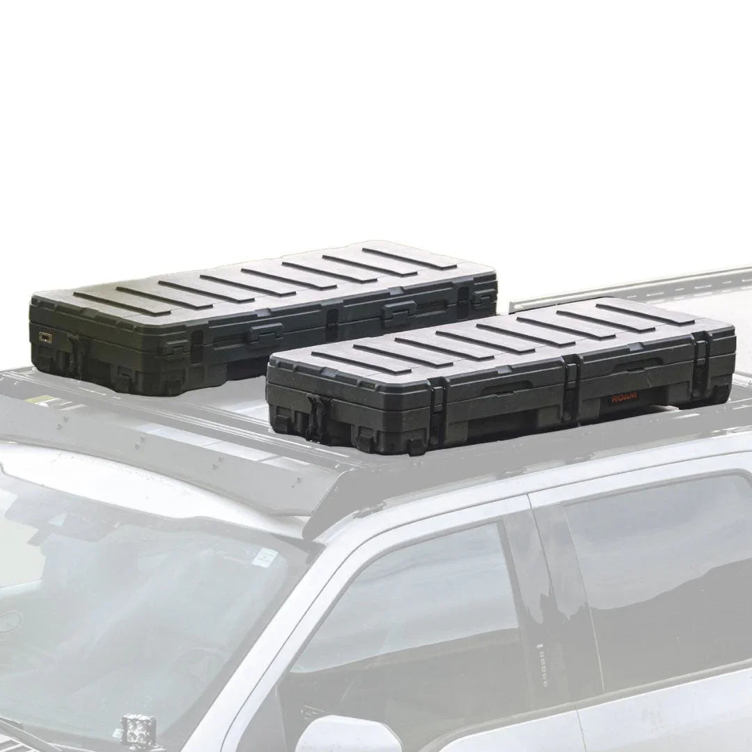 Two black hard shell roof storage boxes mounted on a vehicle roof rack for overlanding gear