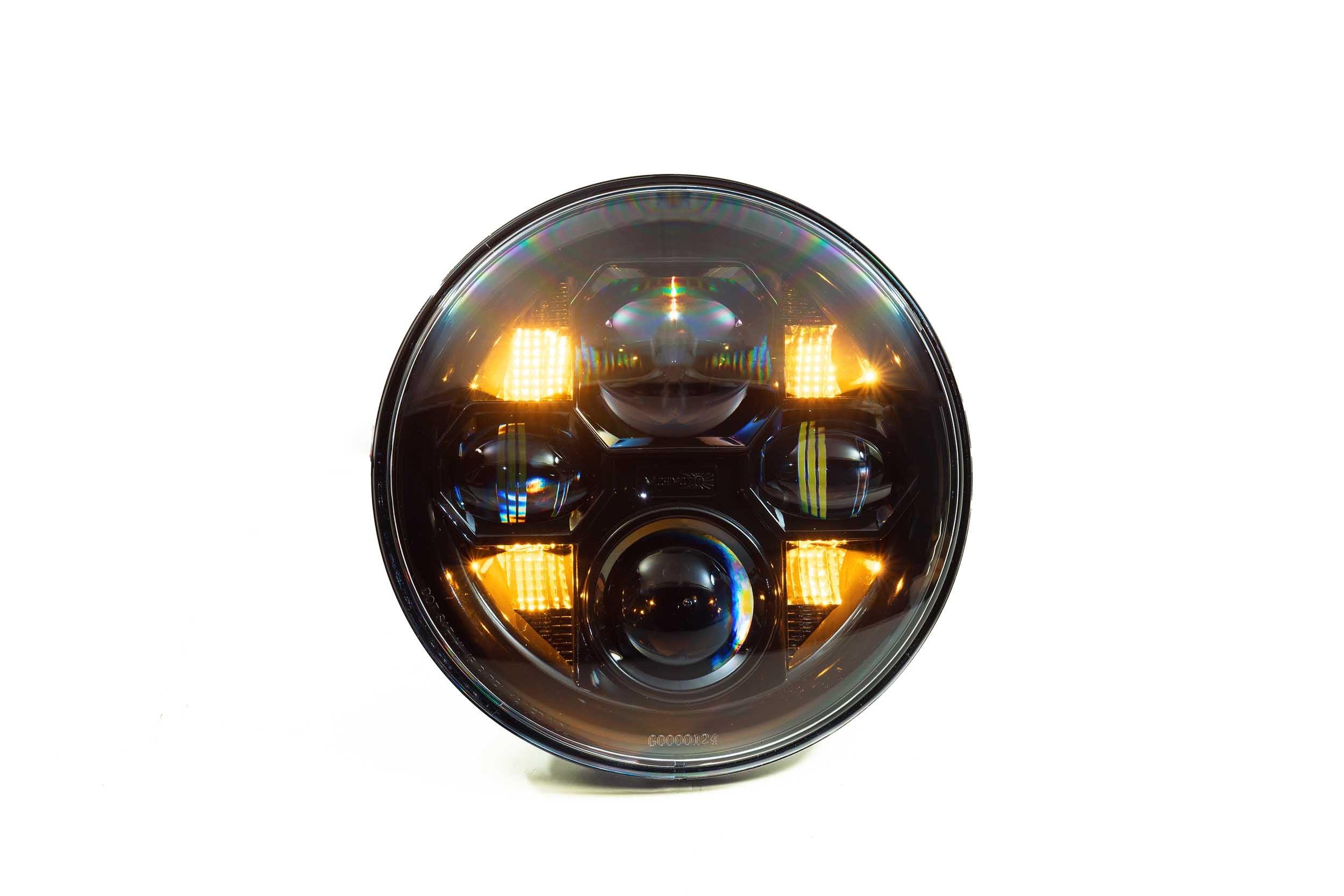Round LED off-road headlight with amber turn signals lit, suitable for adventure vehicles