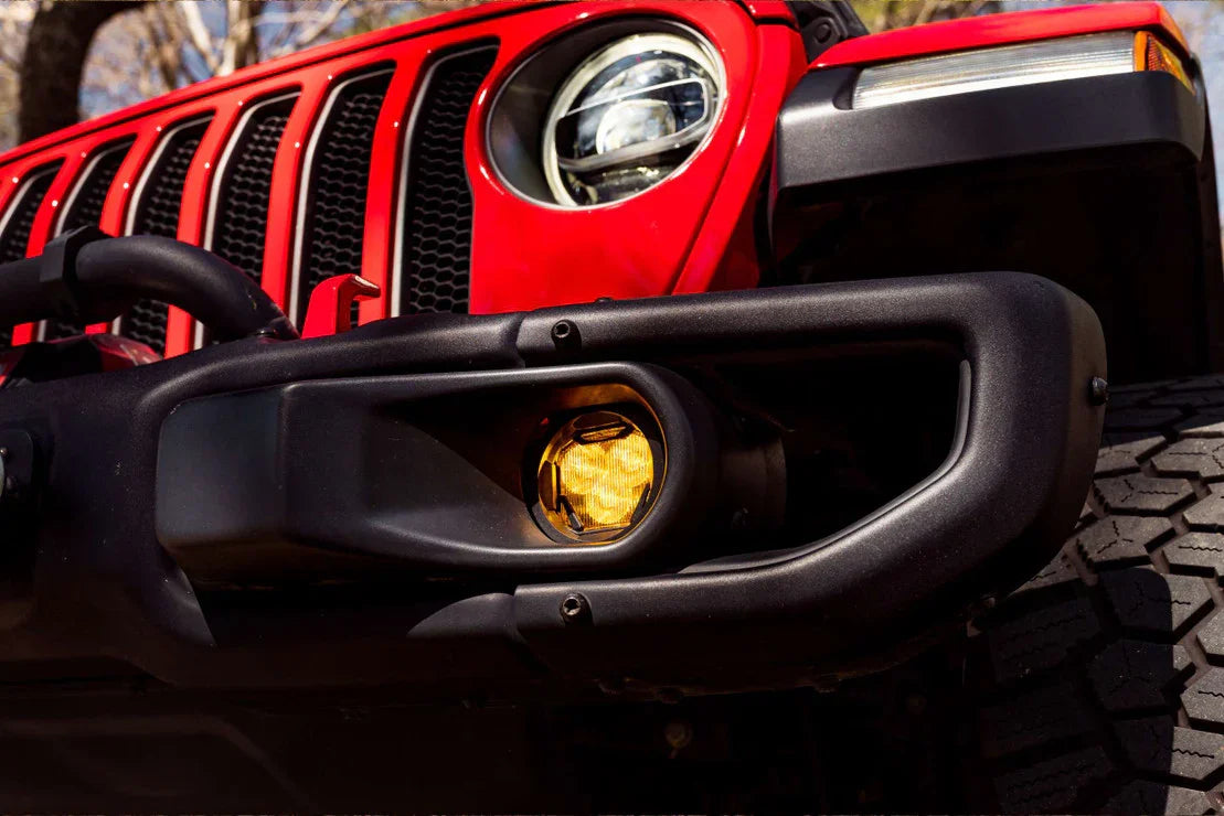 Front bumper and yellow fog light on red Jeep Wrangler, off-road vehicle accessory detail