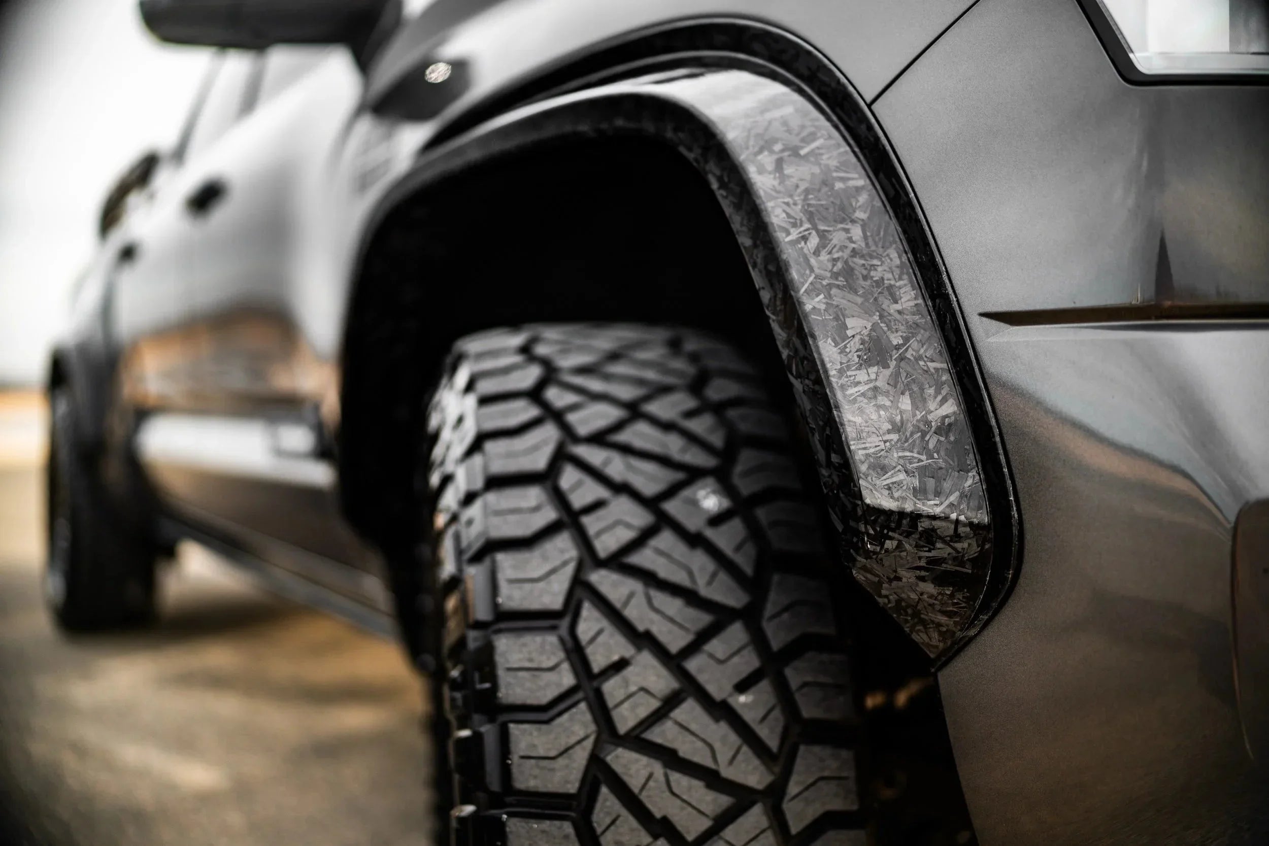 Close-up of off-road tire and textured fender flare on expedition vehicle