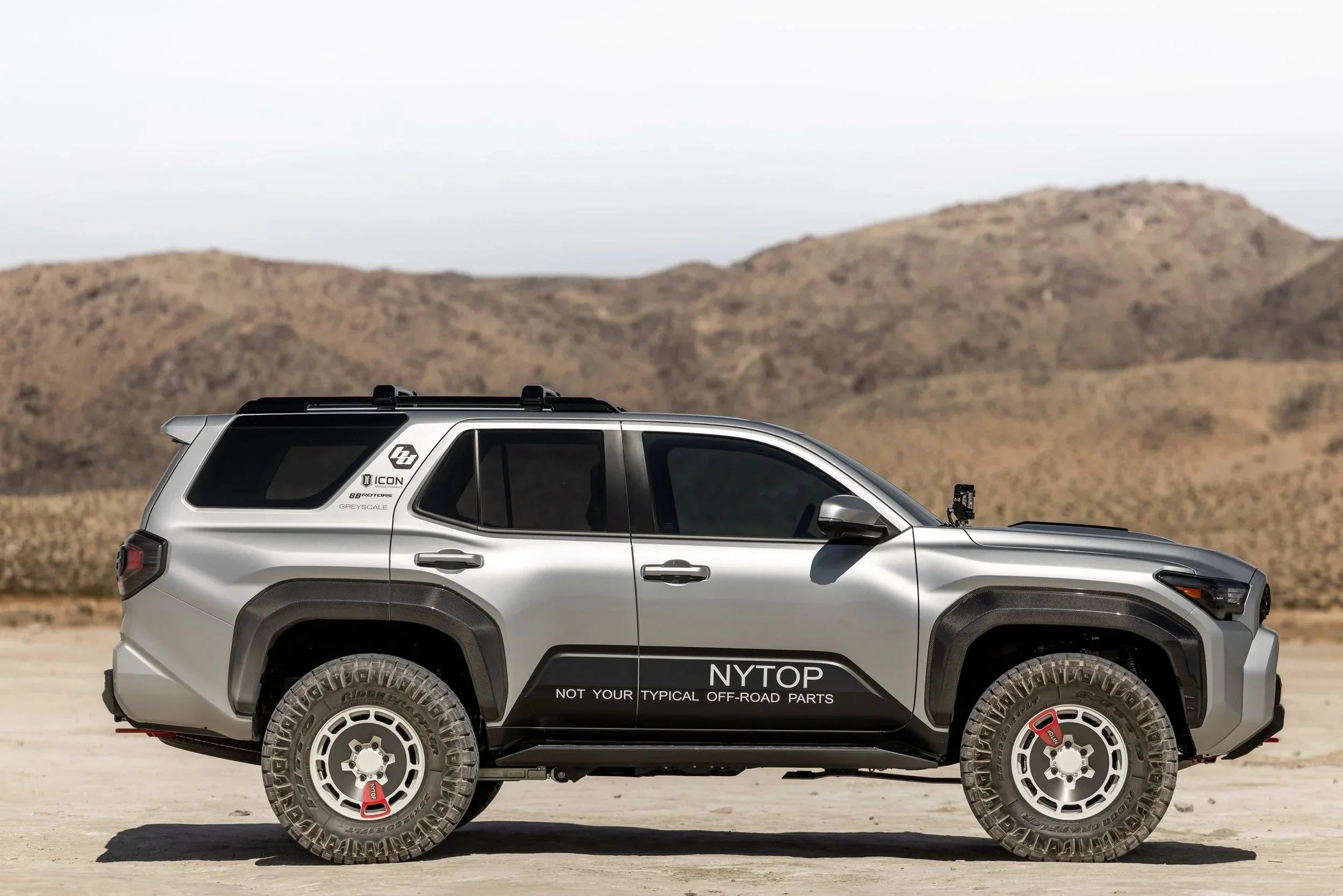 Silver Toyota 4Runner with off-road modifications parked in desert landscape