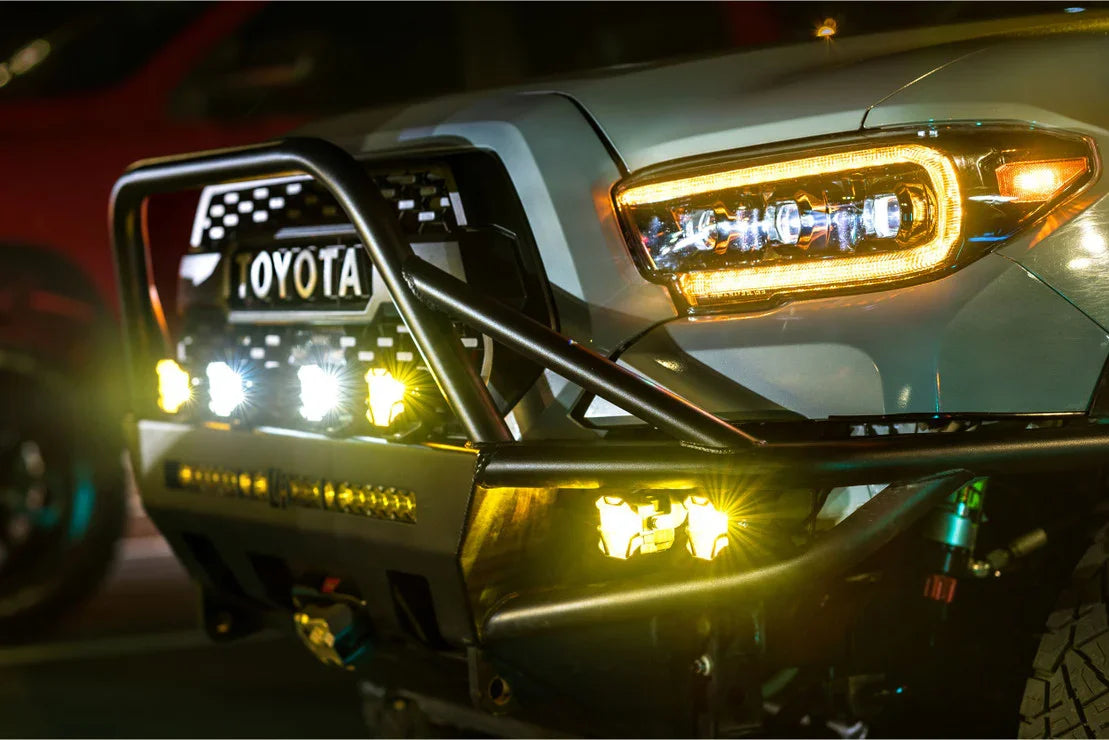 Toyota Tacoma front bumper with off-road LED lights and grille at night