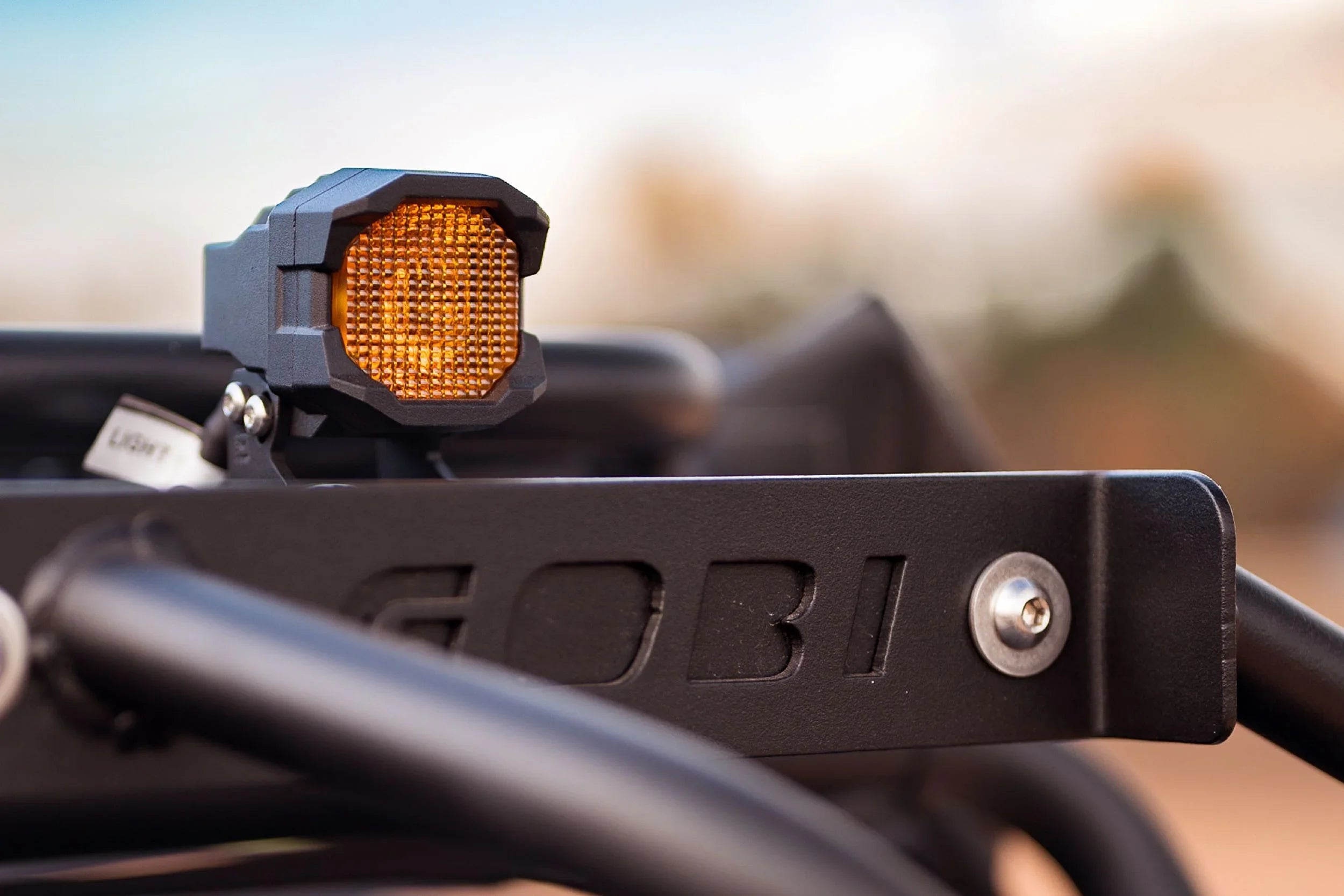 Amber off-road LED light mounted on black metal vehicle roof rack
