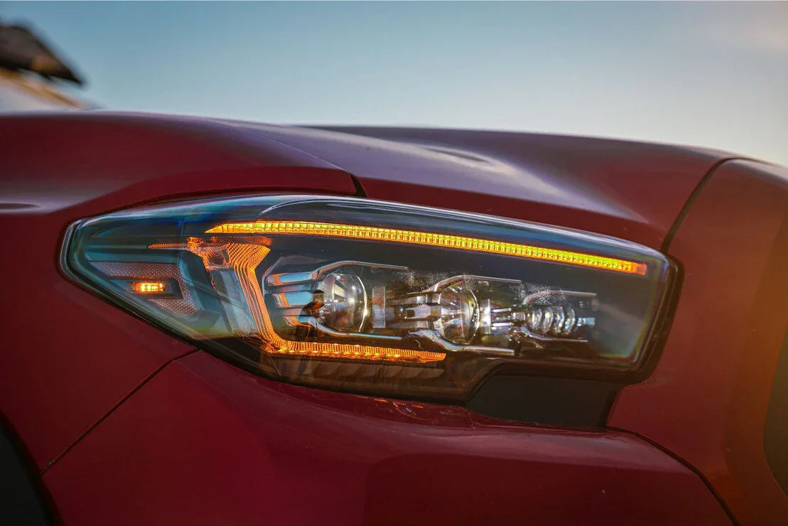 Close-up of LED projector headlight on red Toyota Tacoma truck